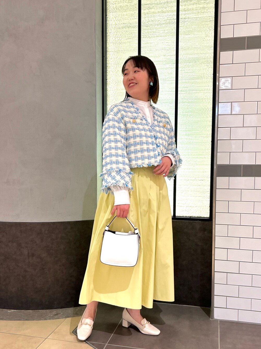 ブルー系のノーカラージャケット、ホワイト系のシャツ/ブラウス、ホワイト系のショルダーバッグを着用したレディースの冬コーディネートの4枚目の写真