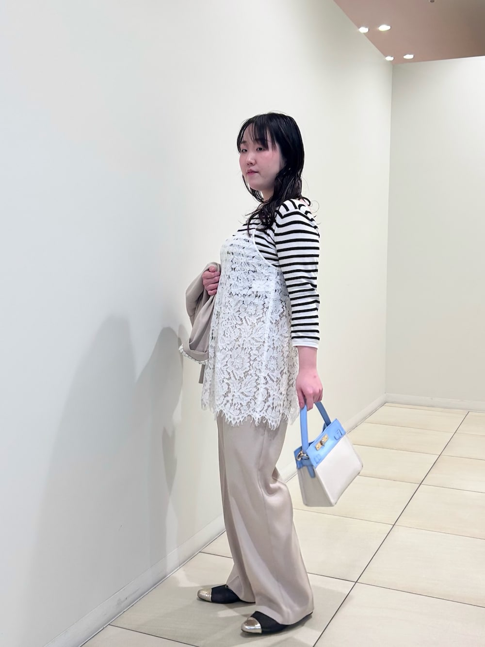 ホワイト系のキャミソール、ホワイト系のニット/セーター、ベージュ系のテーラードジャケットを着用したレディースの春コーディネートの2枚目の写真