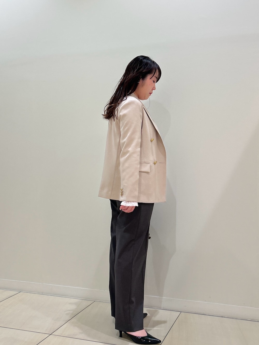 ベージュ系のテーラードジャケット、グレー系のその他パンツ、ホワイト系のTシャツ/カットソーを着用したレディースの春コーディネートの4枚目の写真