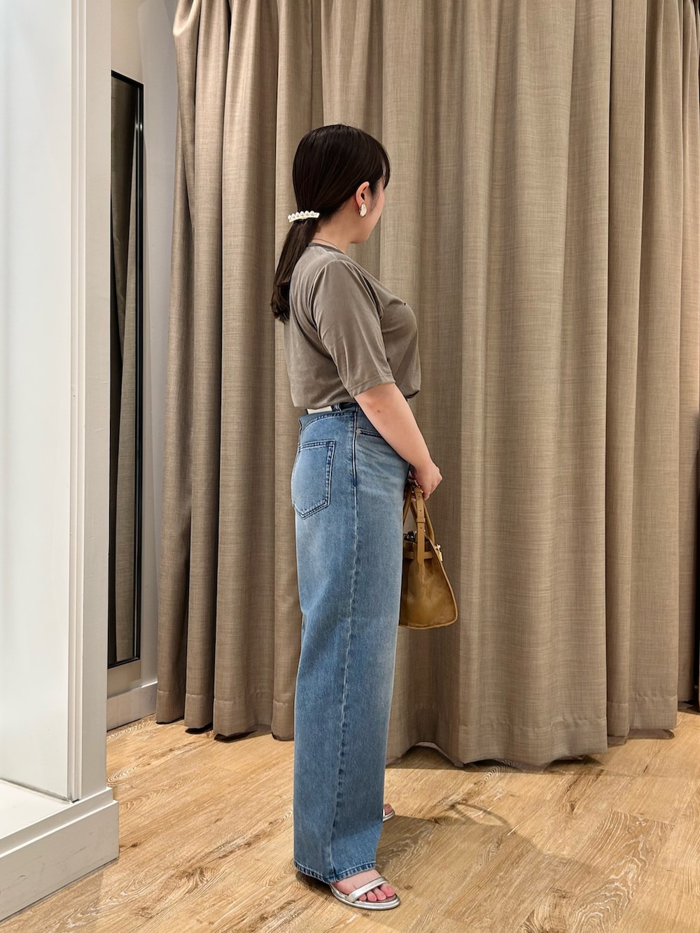 グリーン系のTシャツ/カットソー、ブルー系のデニムパンツ、イエロー系のトートバッグを着用したレディースの秋コーディネートの4枚目の写真