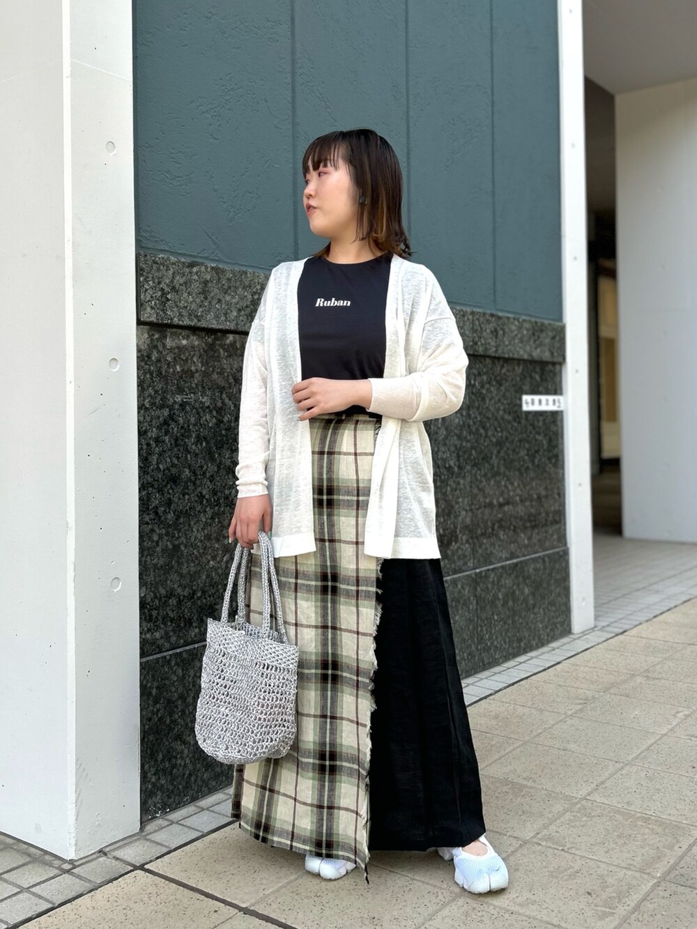 ホワイト系のカーディガン/ボレロ、ブラック系のスカート、シルバー系のバックパック/リュックを着用したレディースの春コーディネートの10枚目の写真