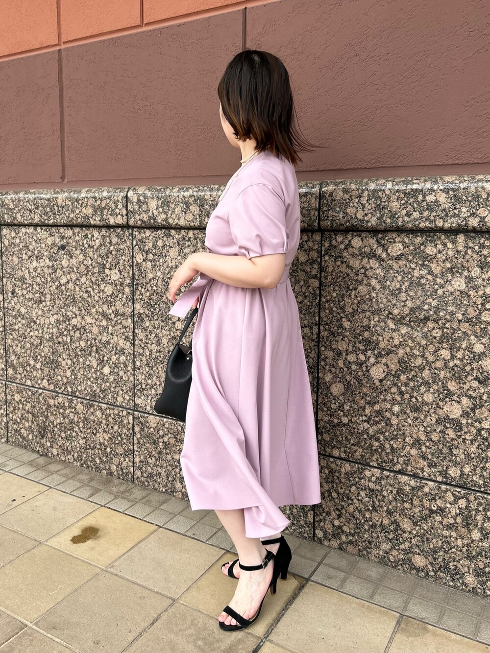 ピンク系のワンピース、ブラック系のトートバッグ、ホワイト系のネックレスを着用したレディースの夏コーディネートの7枚目の写真