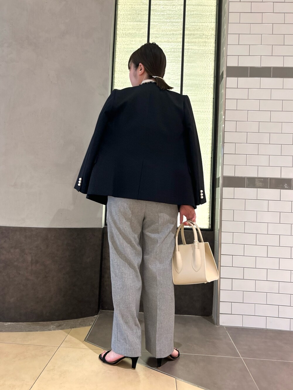 ブルー系のノーカラージャケット、ホワイト系のシャツ/ブラウス、グレー系のその他パンツを着用したレディースの秋コーディネートの3枚目の写真