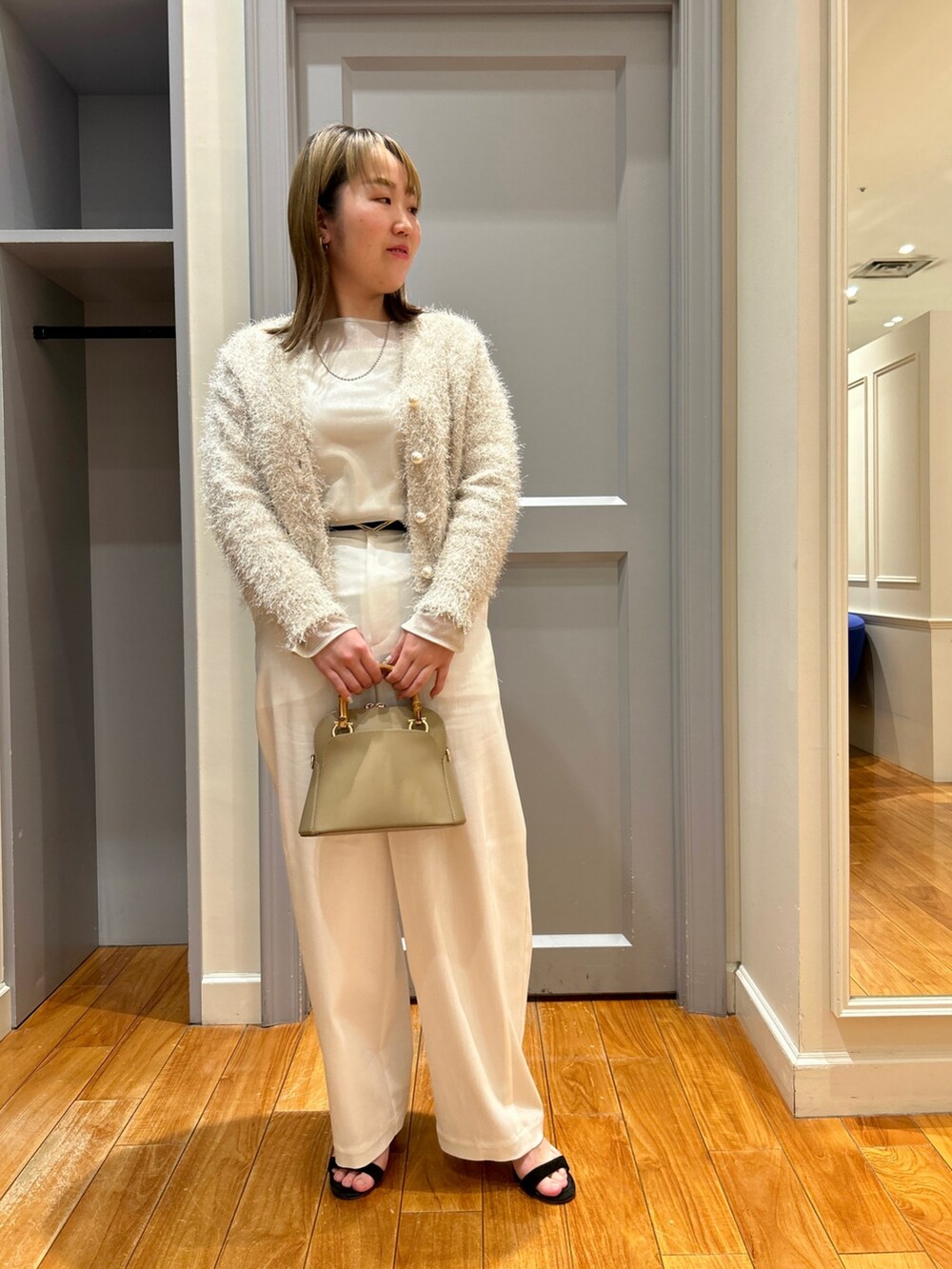 ホワイト系のカーディガン/ボレロ、ベージュ系のTシャツ/カットソー、ホワイト系のタンクトップを着用したレディースの春コーディネートの2枚目の写真