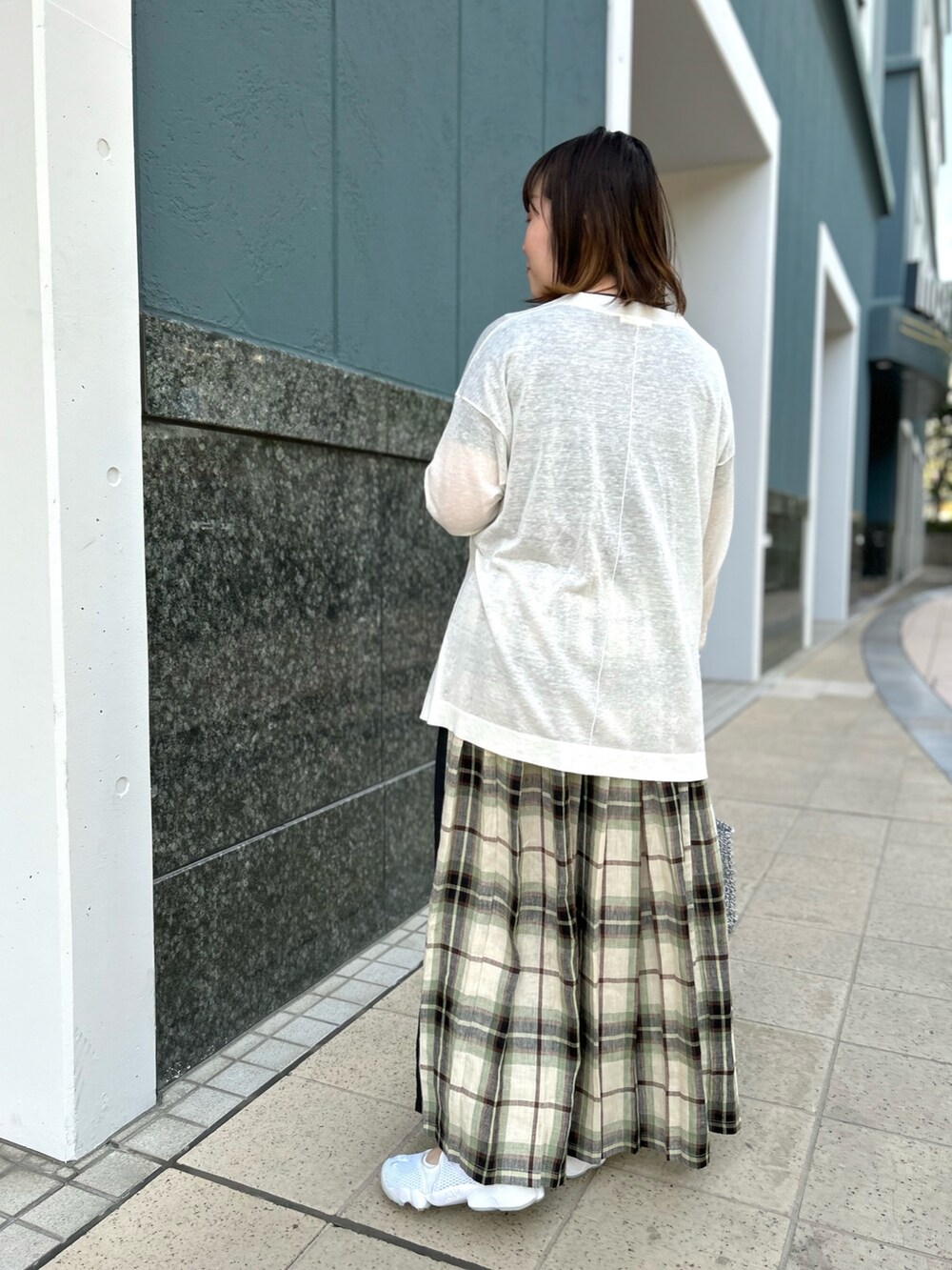 ホワイト系のカーディガン/ボレロ、ブラック系のスカート、シルバー系のバックパック/リュックを着用したレディースの春コーディネートの4枚目の写真