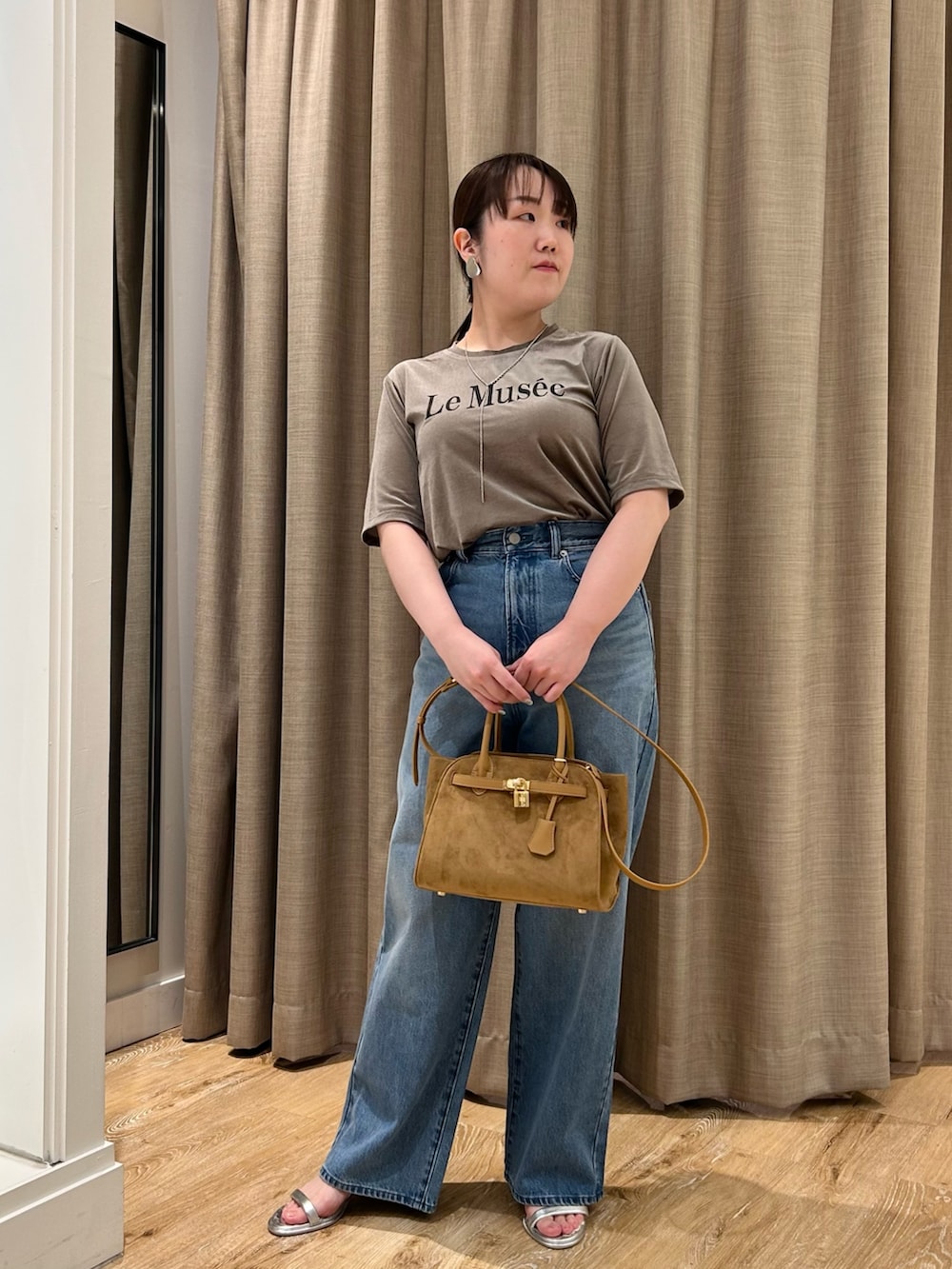 グリーン系のTシャツ/カットソー、ブルー系のデニムパンツ、イエロー系のトートバッグを着用したレディースの秋コーディネートの5枚目の写真