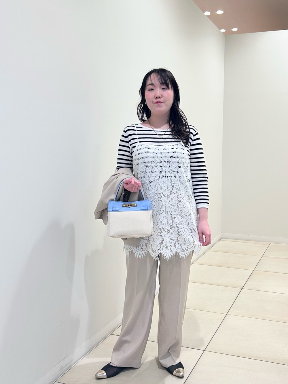 ホワイト系のキャミソール、ホワイト系のニット/セーター、ベージュ系のテーラードジャケットを着用したレディースの春コーディネートの5枚目の写真