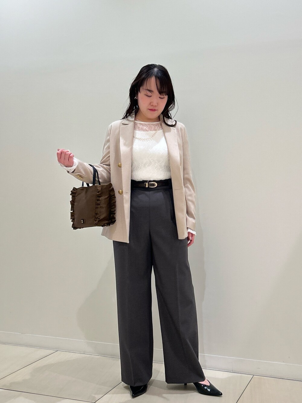 ベージュ系のテーラードジャケット、グレー系のその他パンツ、ホワイト系のTシャツ/カットソーを着用したレディースの春コーディネートの9枚目の写真