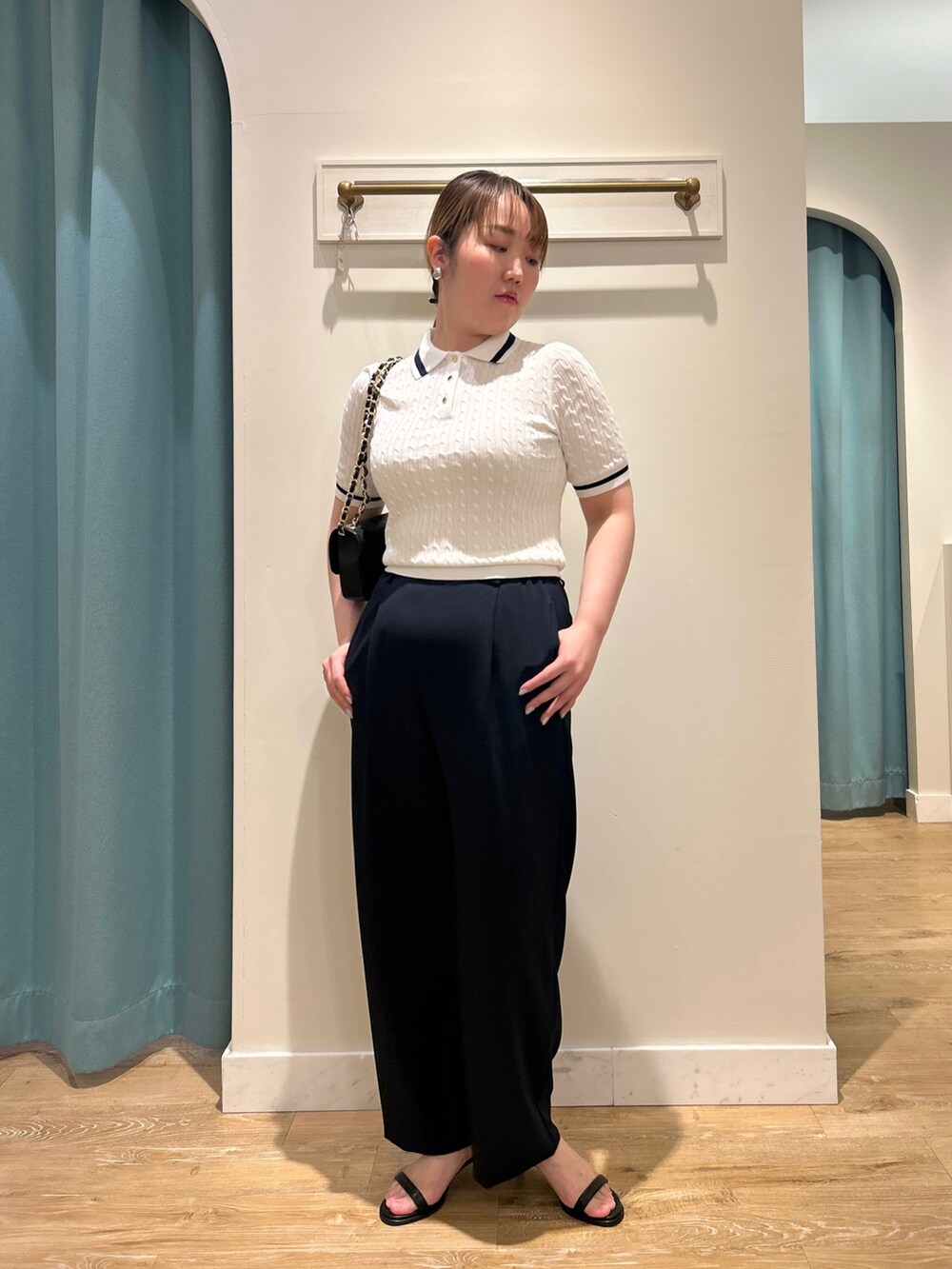 ホワイト系のニット/セーター、ブルー系のその他パンツ、ブラック系のショルダーバッグを着用したレディースの夏コーディネートの9枚目の写真