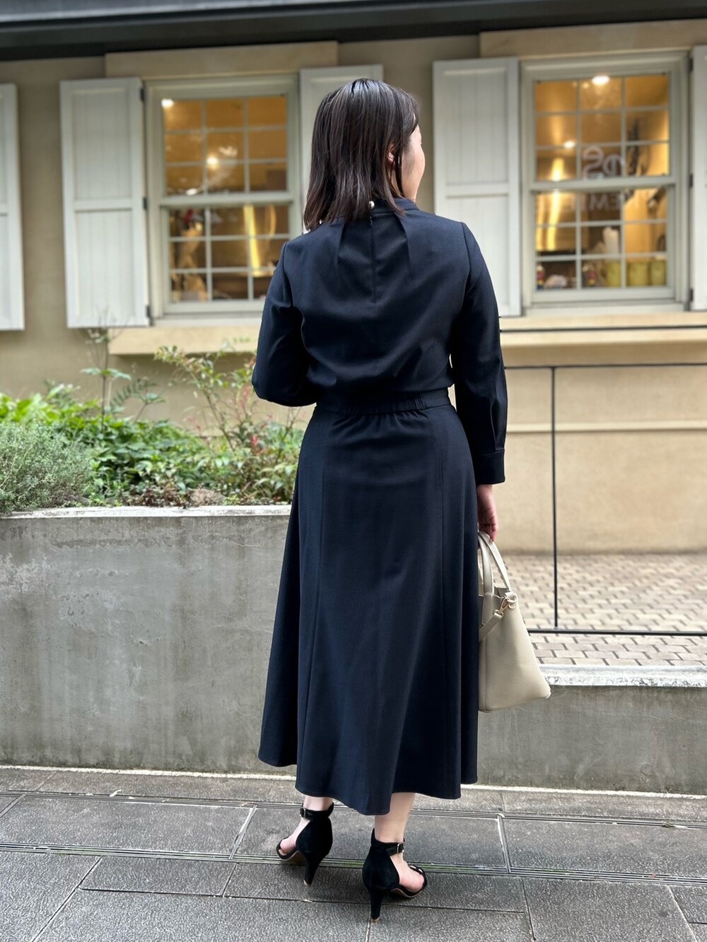 ブルー系のシャツ/ブラウス、ブルー系のスカート、ホワイト系のトートバッグを着用したレディースの秋コーディネートの4枚目の写真