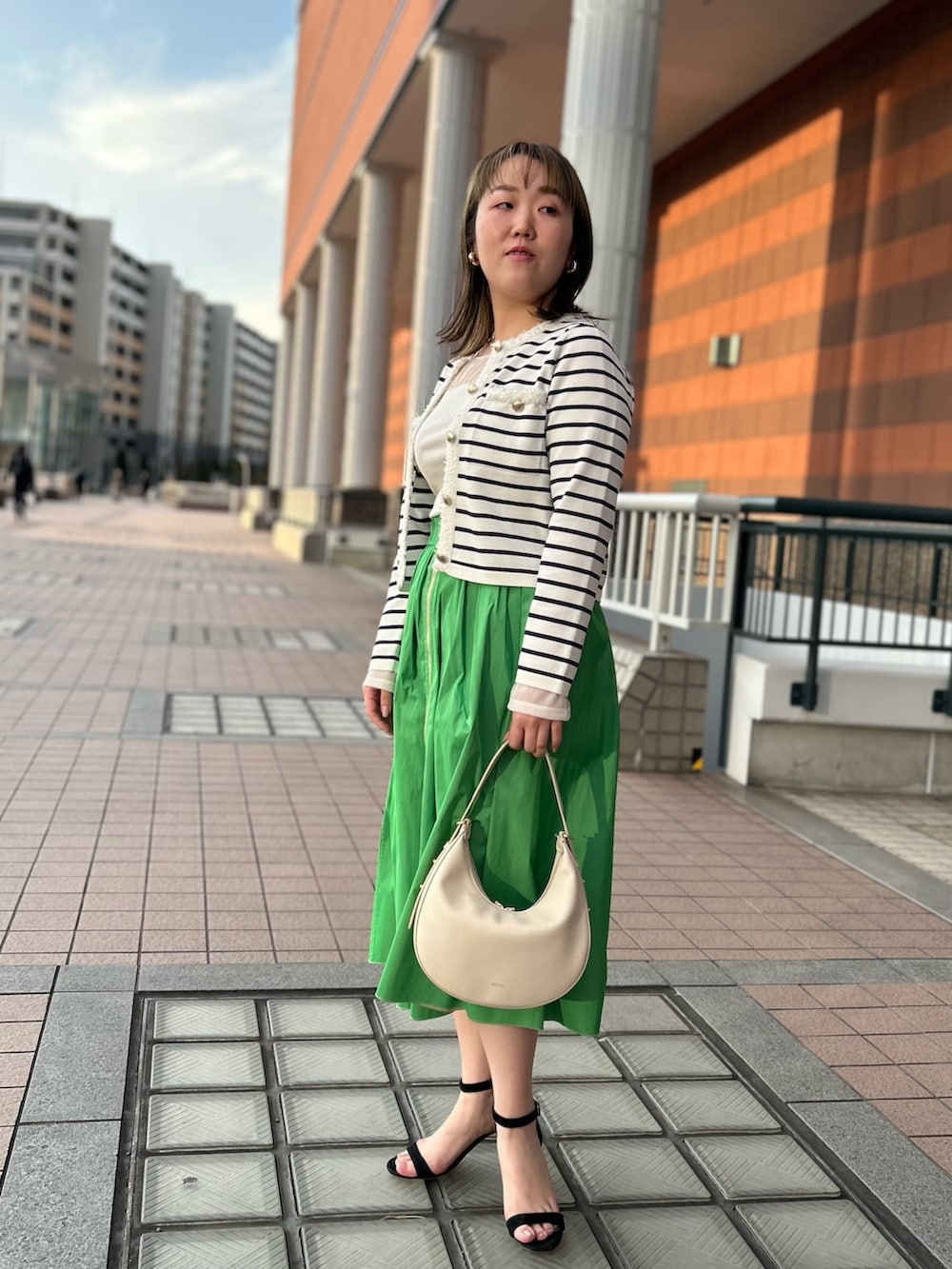 ホワイト系のカーディガン/ボレロ、グリーン系のスカート、ホワイト系のTシャツ/カットソーを着用したレディースの冬コーディネートの6枚目の写真