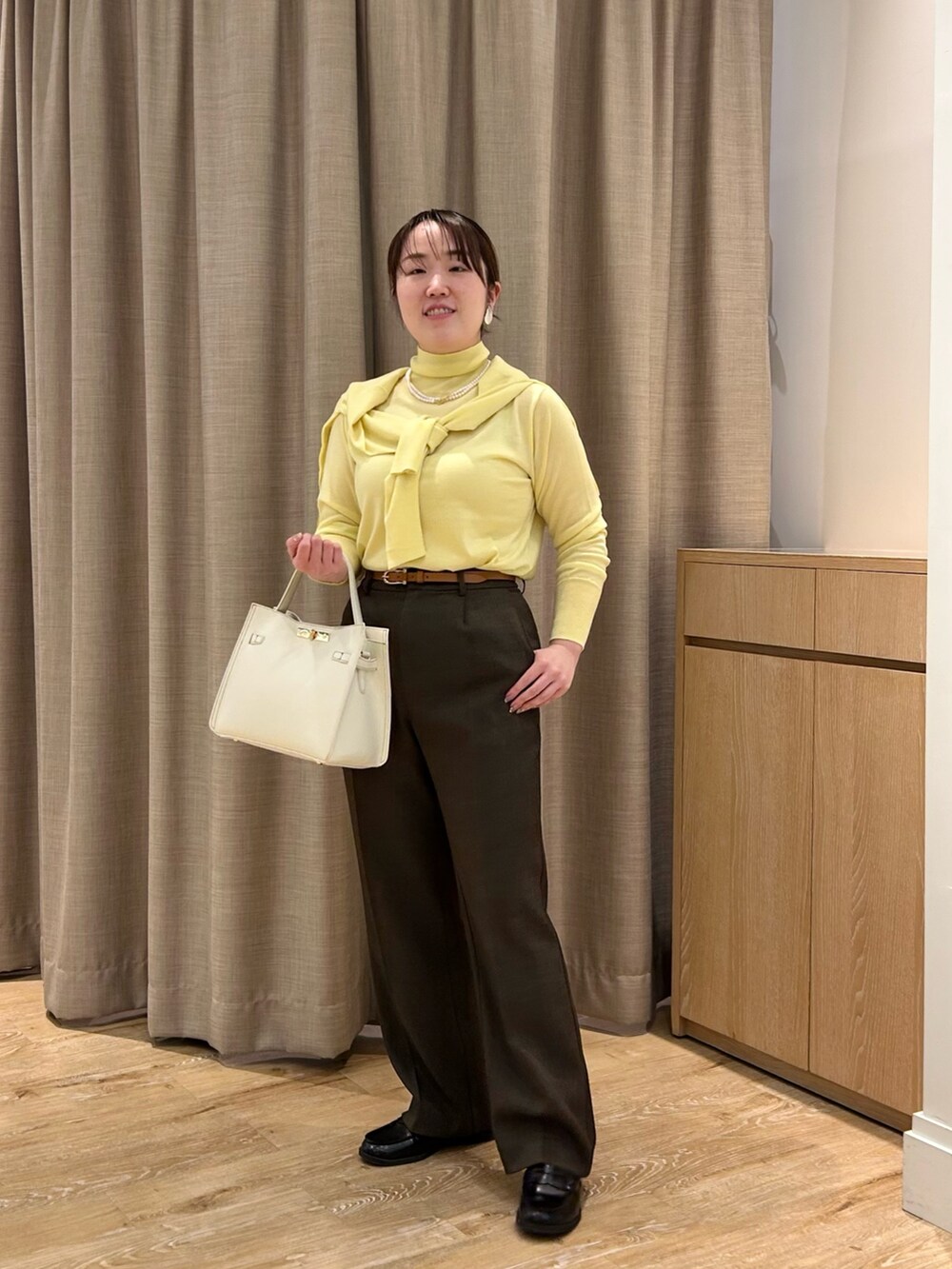 イエロー系のニット/セーター、イエロー系のカーディガン/ボレロ、ブラウン系のその他パンツを着用したレディースの秋コーディネートの9枚目の写真