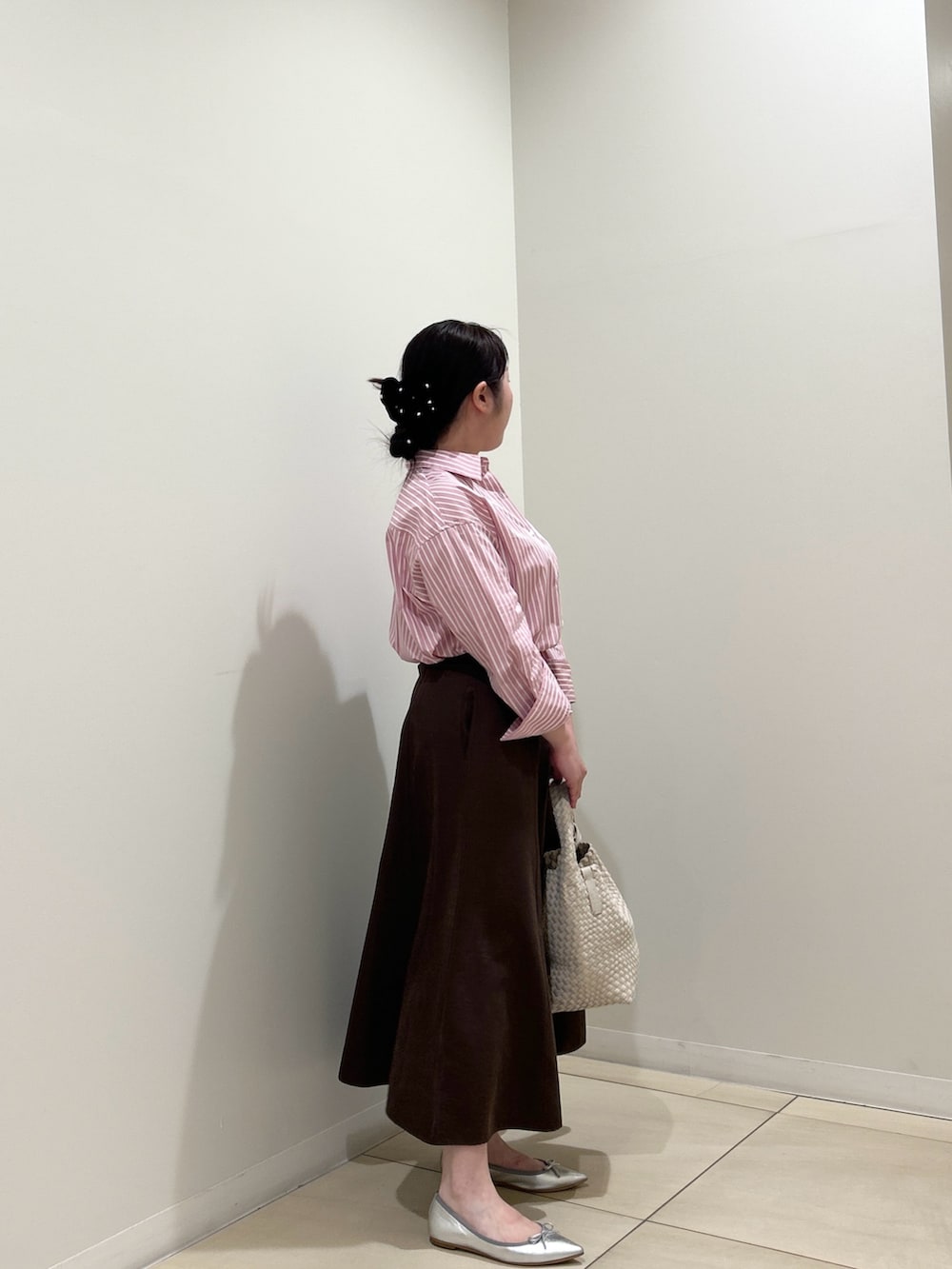 ピンク系のシャツ/ブラウス、ブラウン系のスカート、ホワイト系のショルダーバッグを着用したレディースの秋コーディネートの4枚目の写真