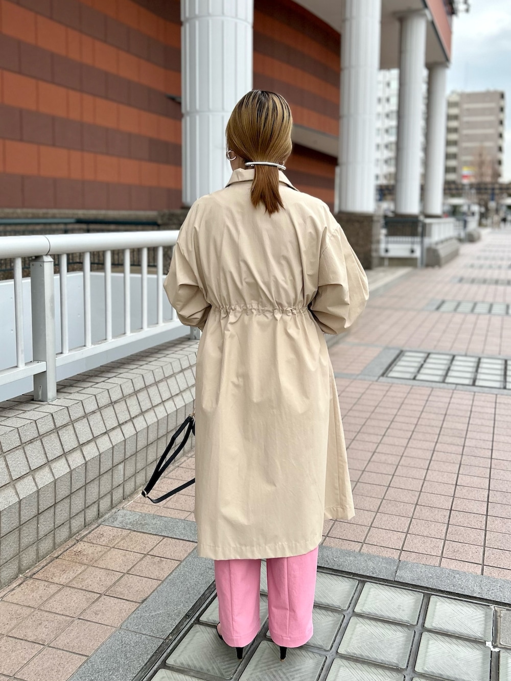 ベージュ系のその他アウター、ブラック系のニット/セーター、ピンク系のチノパンツを着用したレディースの春コーディネートの5枚目の写真