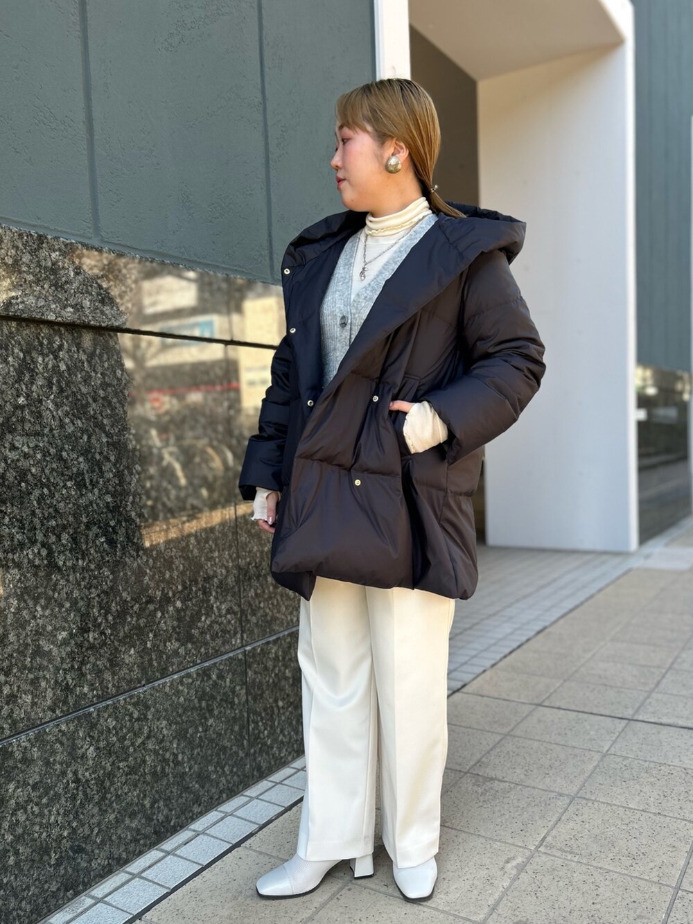 ブラック系のダウンジャケット/コート、グレー系のカーディガン/ボレロ、ホワイト系のTシャツ/カットソーを着用したレディースの冬コーディネートの6枚目の写真