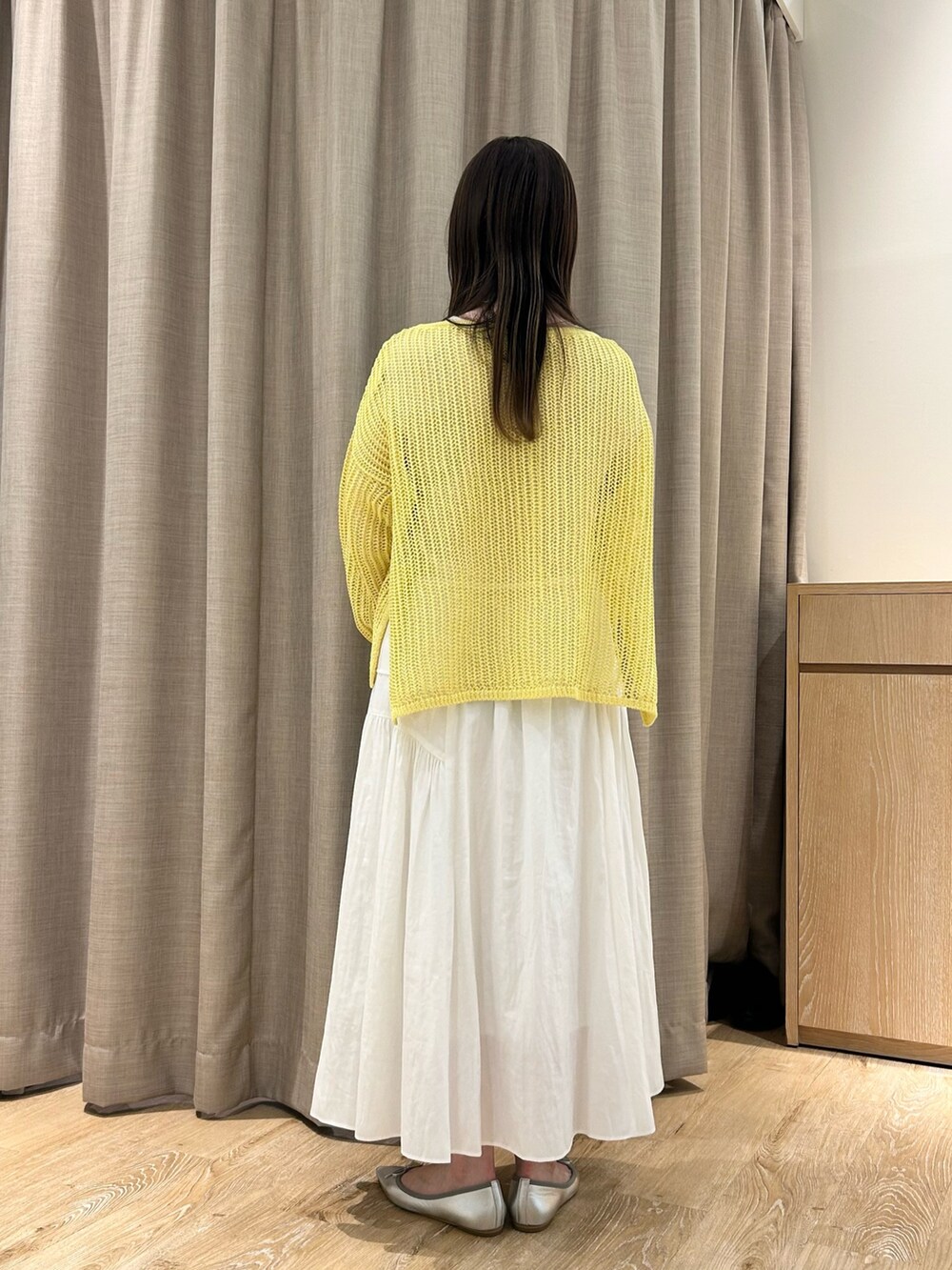イエロー系のニット/セーター、ホワイト系のTシャツ/カットソー、ホワイト系のスカートを着用したレディースの春コーディネートの3枚目の写真