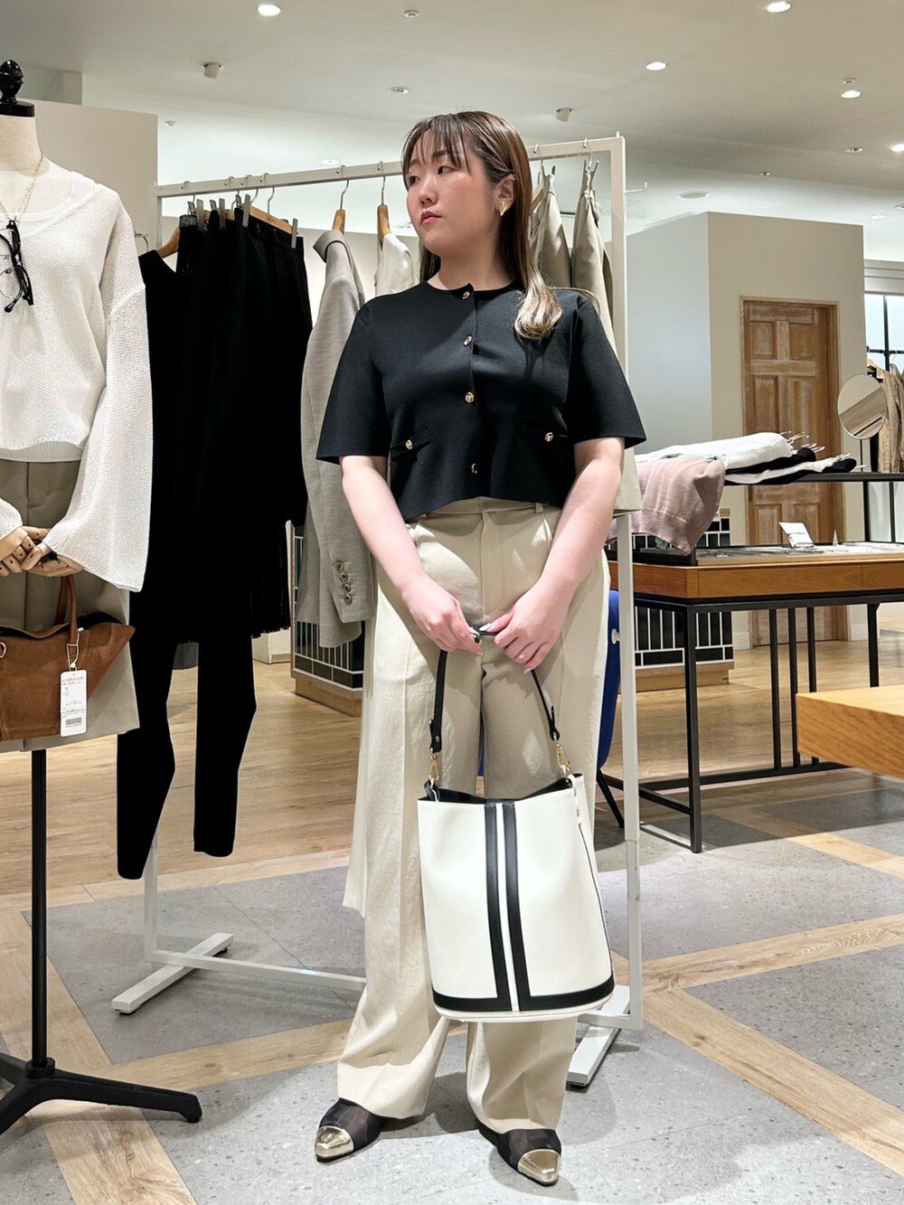 ブラック系のノーカラージャケット、ベージュ系のその他パンツ、ホワイト系のショルダーバッグを着用したレディースの夏コーディネートの6枚目の写真