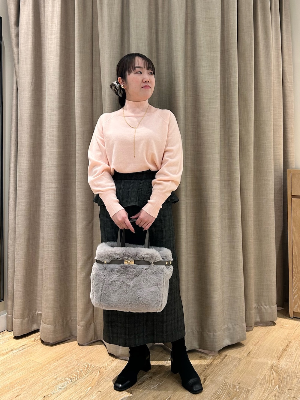 ピンク系のニット/セーター、ブラック系のスカート、ベージュ系のトートバッグを着用したレディースの冬コーディネートの6枚目の写真