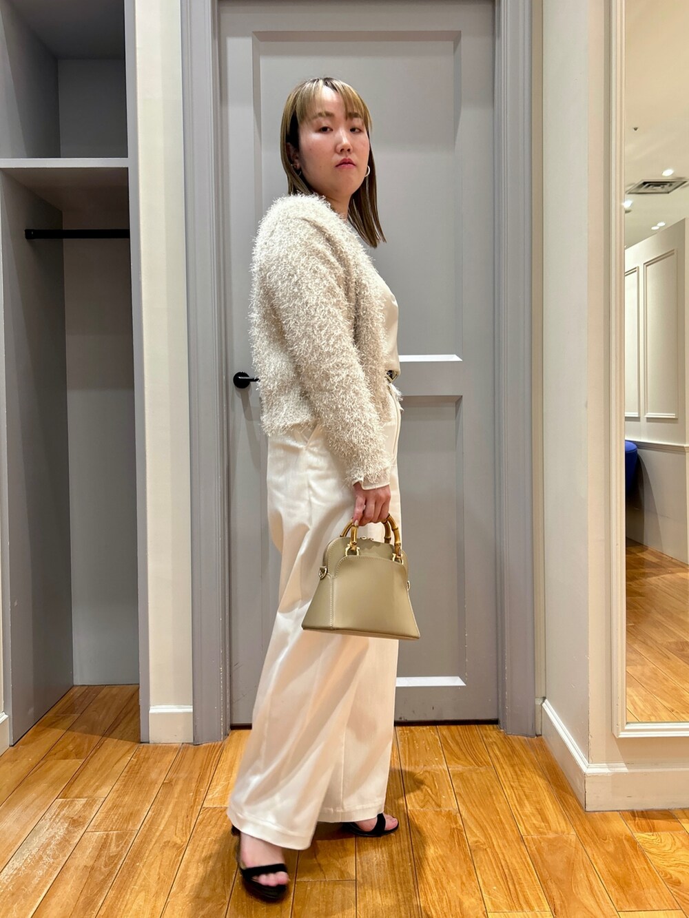 ホワイト系のカーディガン/ボレロ、ベージュ系のTシャツ/カットソー、ホワイト系のタンクトップを着用したレディースの春コーディネートの3枚目の写真