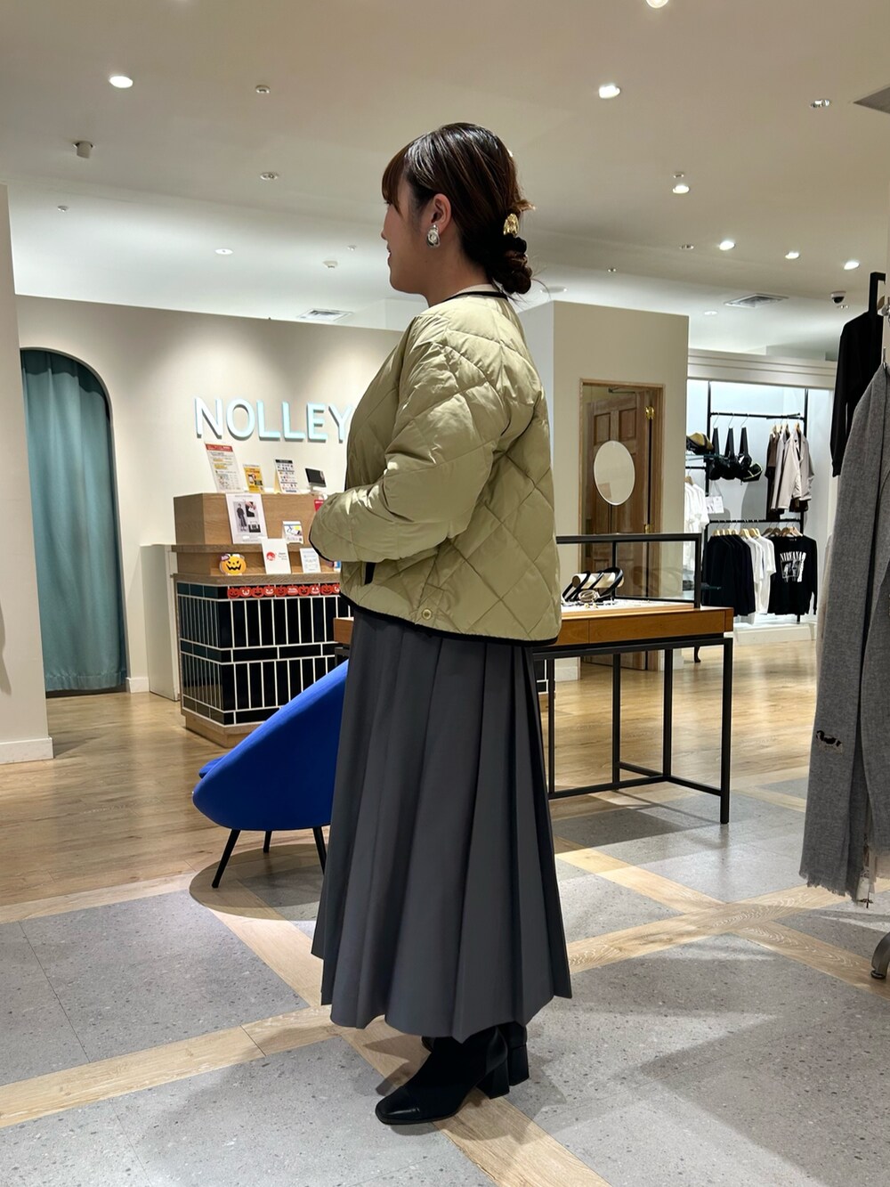 ベージュ系のダウンジャケット/コート、ホワイト系のカーディガン/ボレロ、グレー系のスカートを着用したレディースの秋コーディネートの2枚目の写真