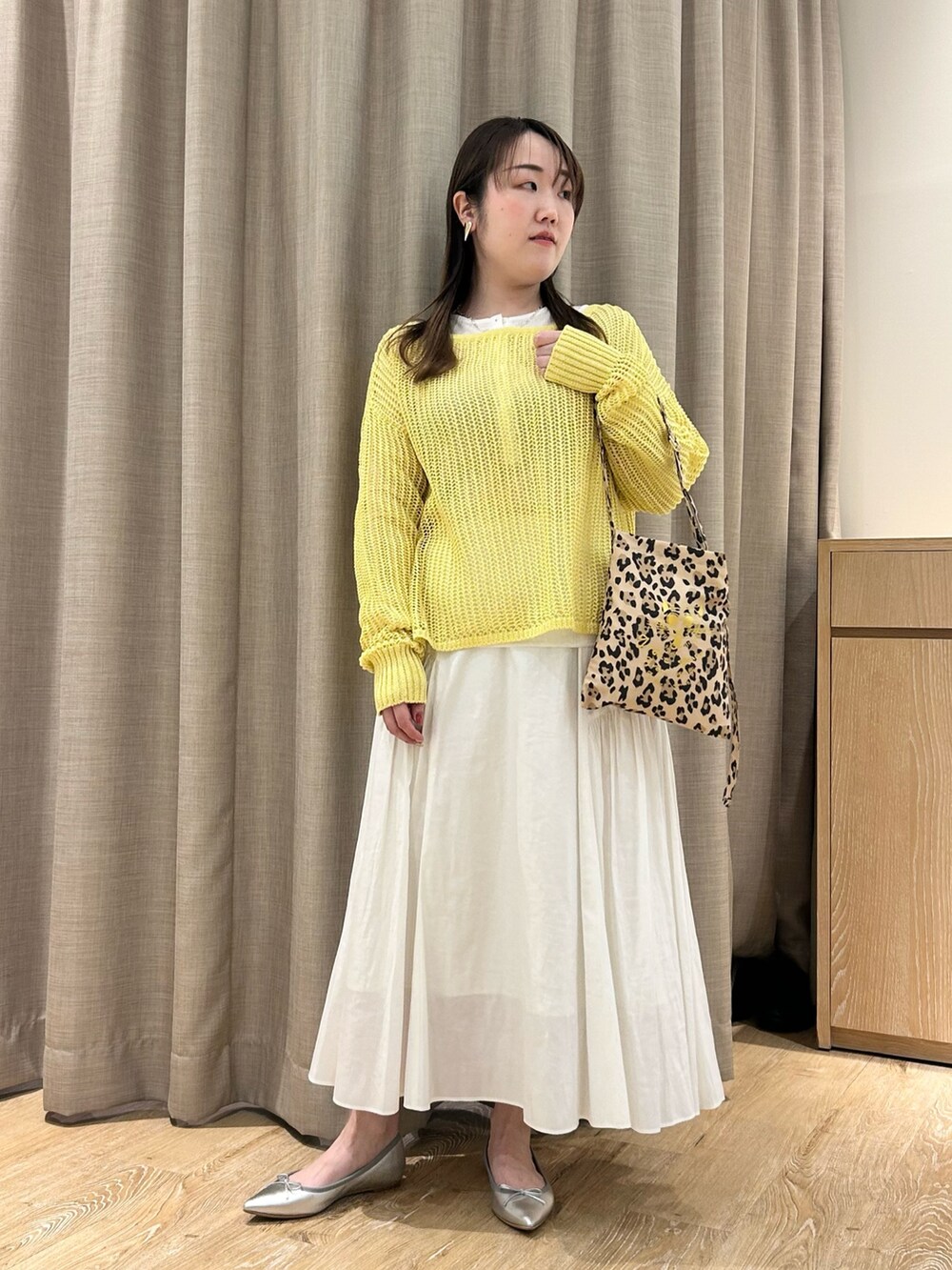 イエロー系のニット/セーター、ホワイト系のTシャツ/カットソー、ホワイト系のスカートを着用したレディースの春コーディネートの8枚目の写真