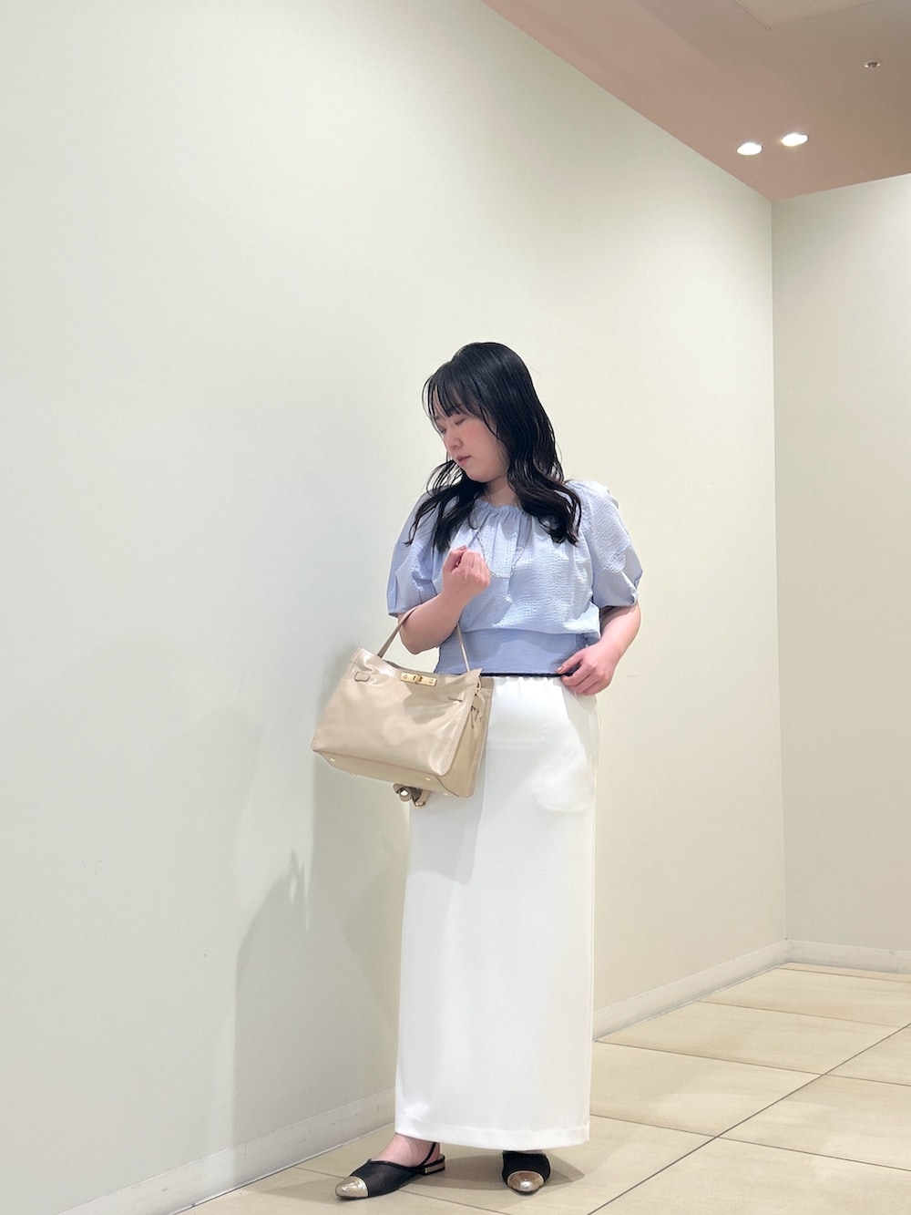 ブルー系のシャツ/ブラウス、ホワイト系のスカート、ベージュ系のトートバッグを着用したレディースの夏コーディネートの6枚目の写真