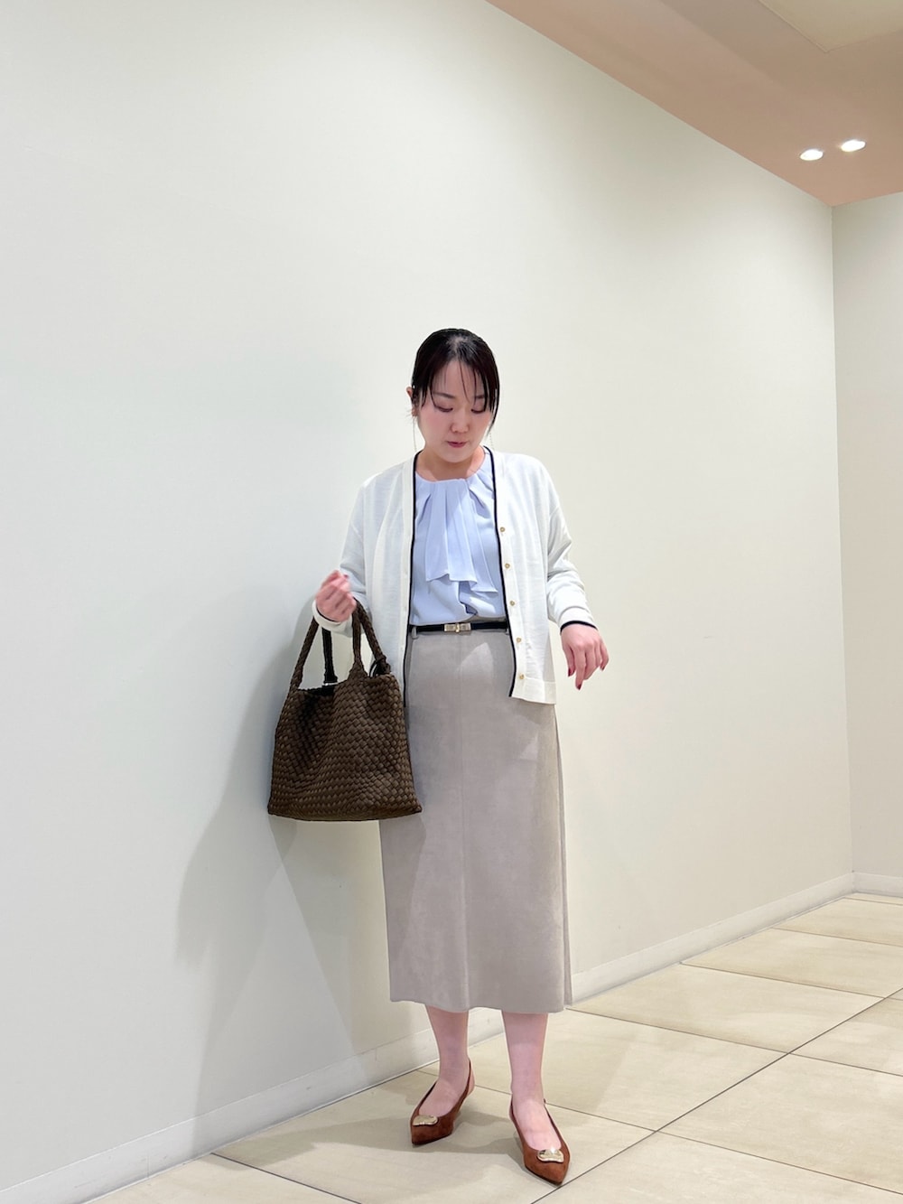 ホワイト系のカーディガン/ボレロ、ブルー系のシャツ/ブラウス、ベージュ系のスカートを着用したレディースの秋コーディネートの6枚目の写真