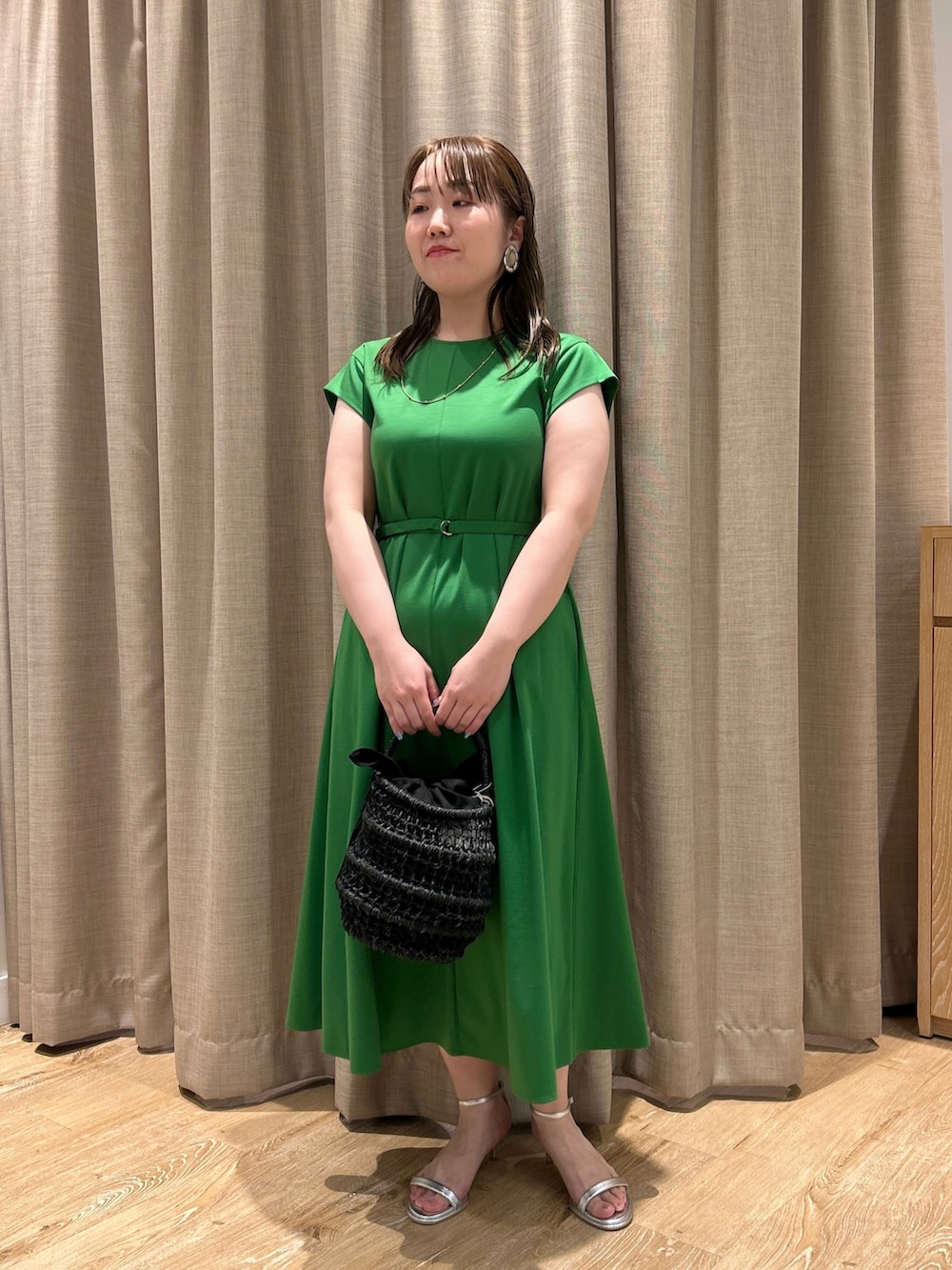 グリーン系のワンピース、ブラック系のかごバッグ、シルバー系のサンダルを着用したレディースの夏コーディネートの7枚目の写真