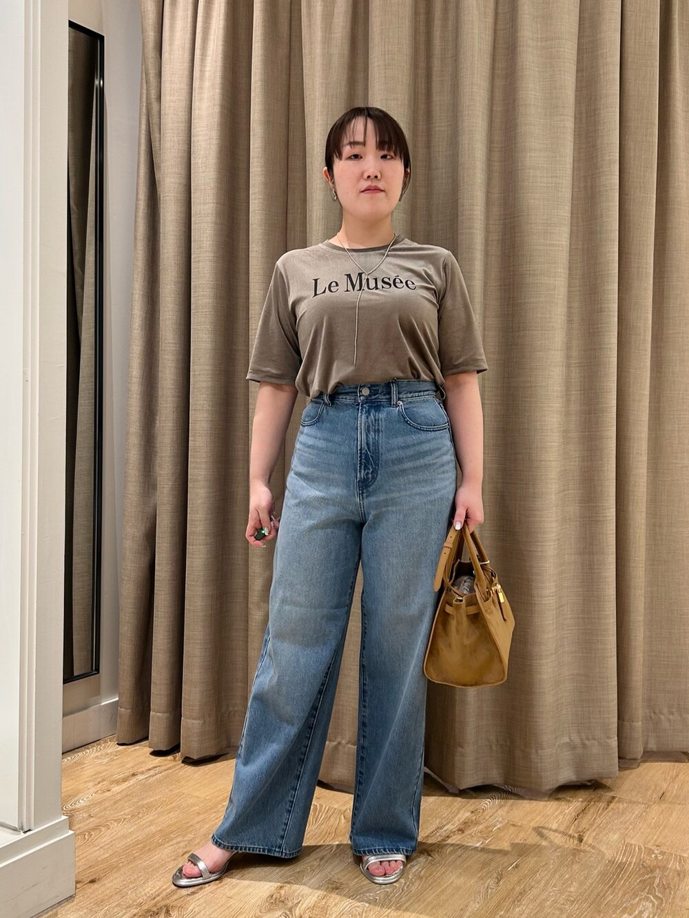 グリーン系のTシャツ/カットソー、ブルー系のデニムパンツ、イエロー系のトートバッグを着用したレディースの秋コーディネートの7枚目の写真