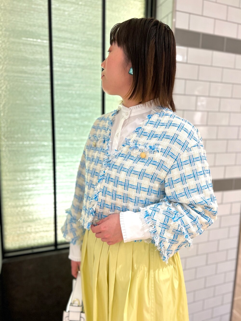 ブルー系のノーカラージャケット、ホワイト系のシャツ/ブラウス、ホワイト系のショルダーバッグを着用したレディースの冬コーディネートの8枚目の写真