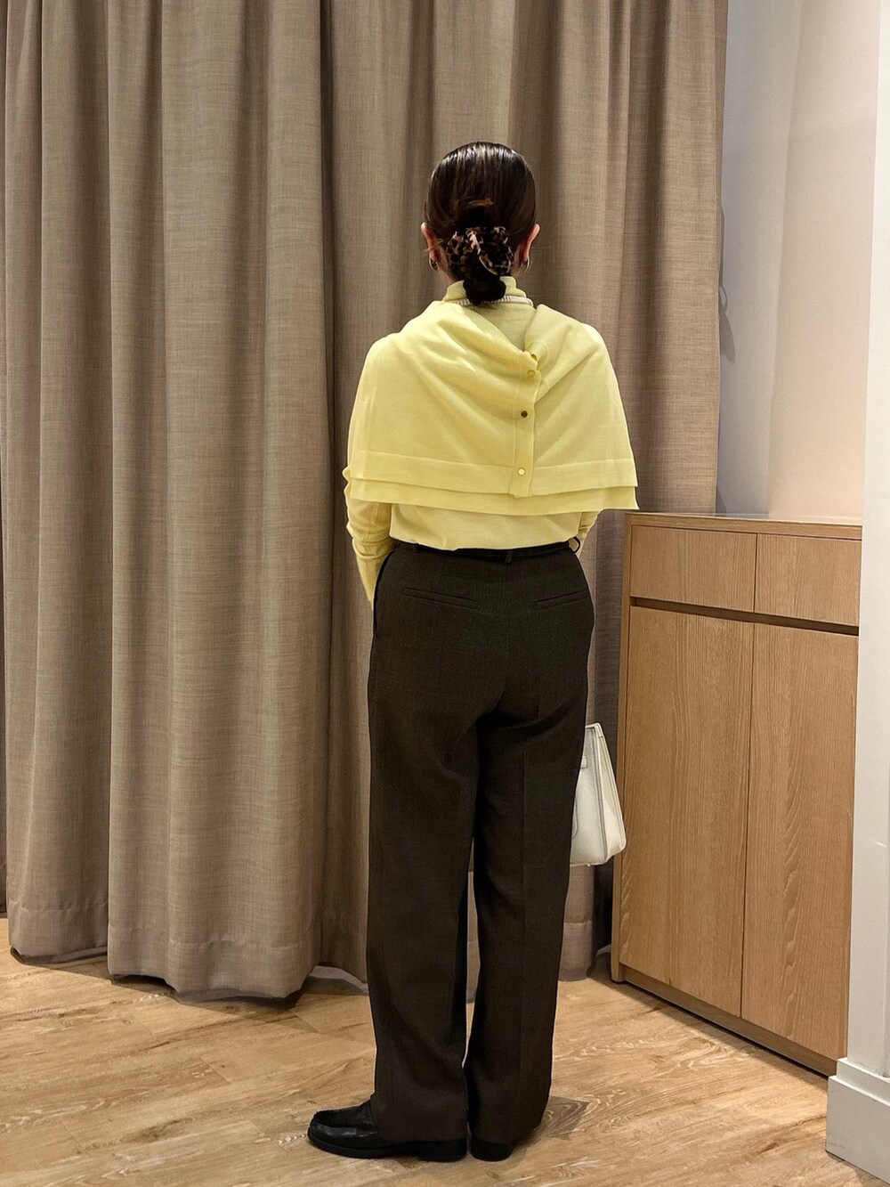 イエロー系のニット/セーター、イエロー系のカーディガン/ボレロ、ブラウン系のその他パンツを着用したレディースの秋コーディネートの3枚目の写真