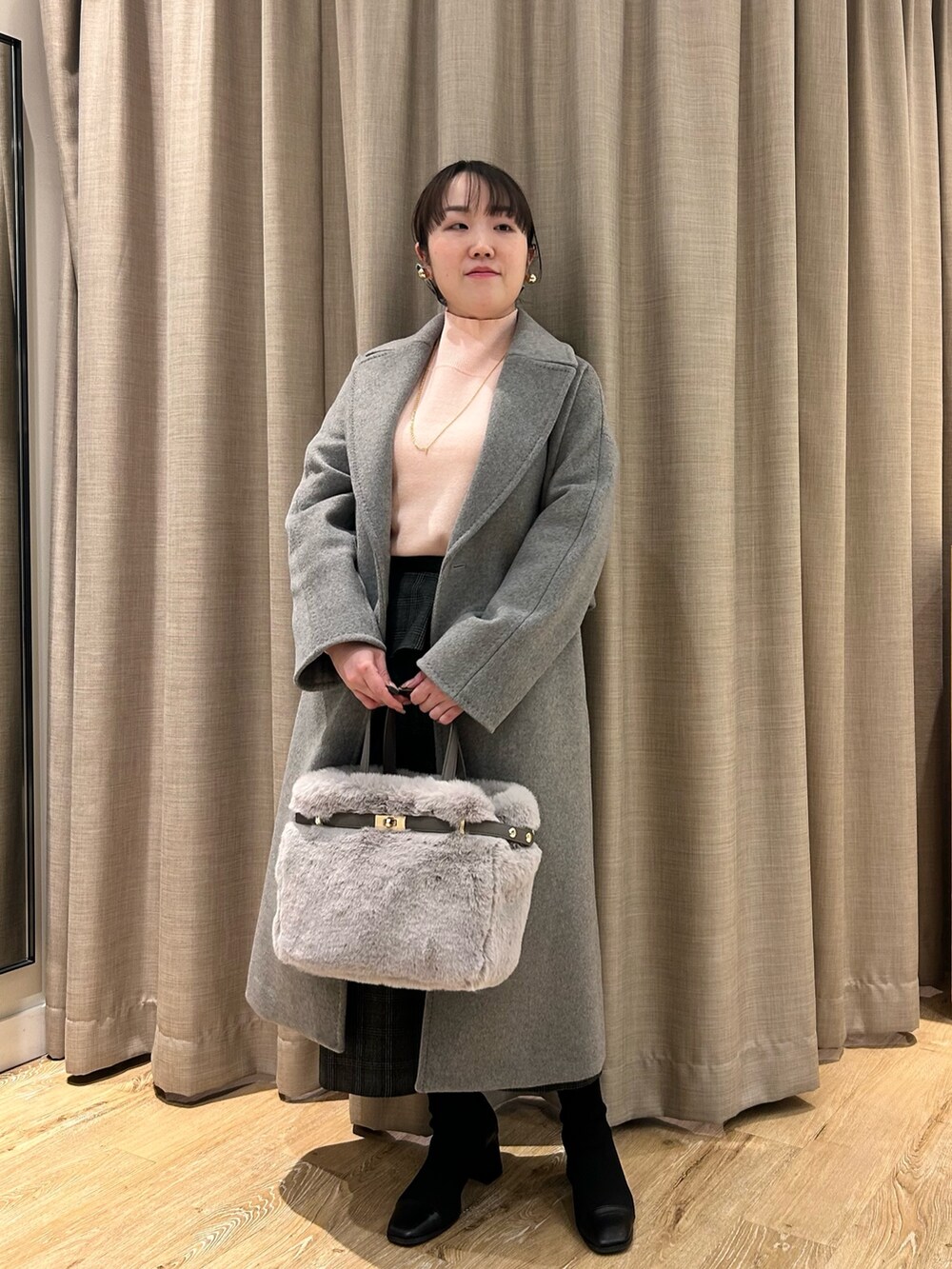 グレー系のその他アウター、ピンク系のニット/セーター、ブラック系のスカートを着用したレディースの冬コーディネートの7枚目の写真