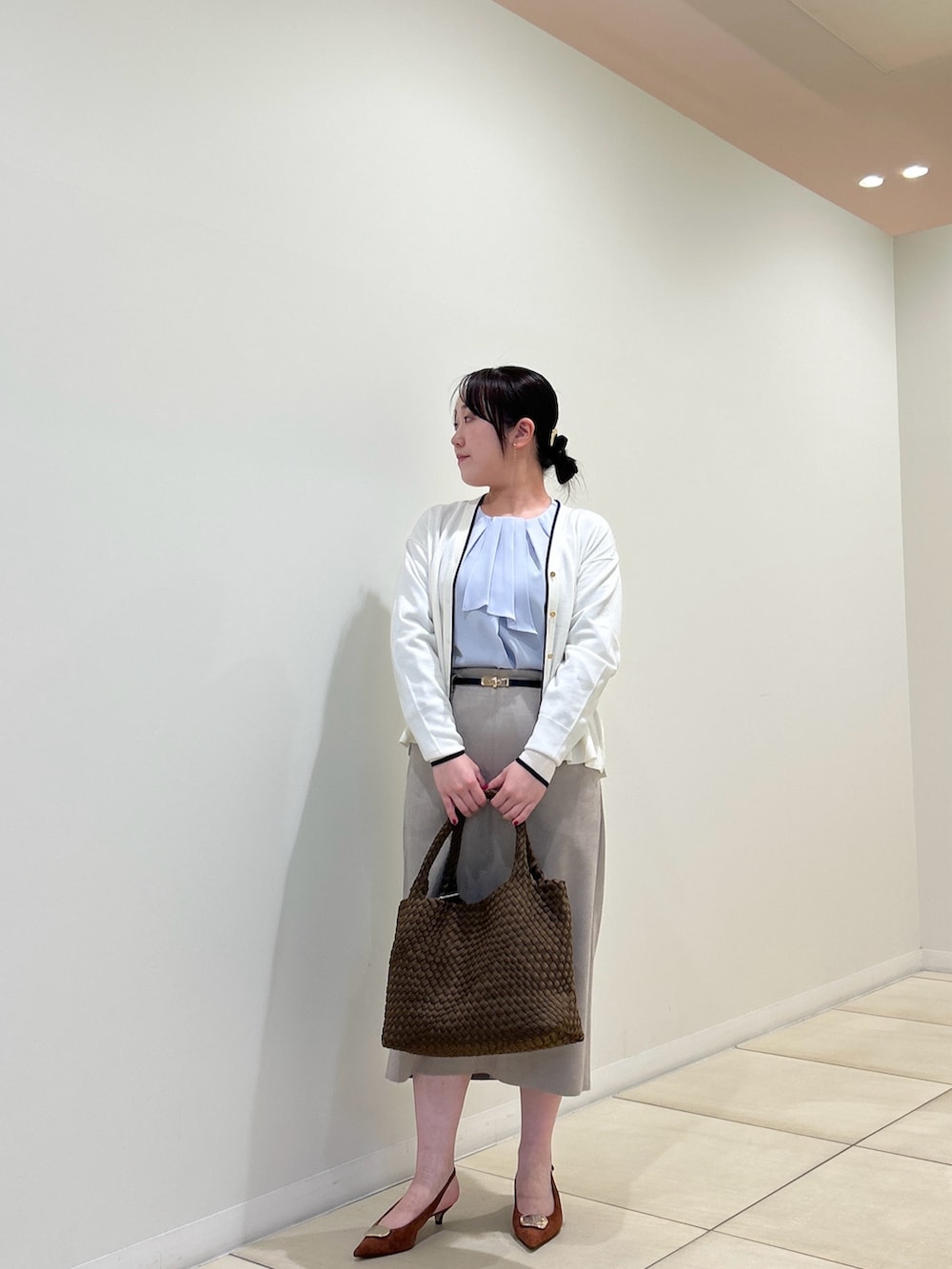 ホワイト系のカーディガン/ボレロ、ブルー系のシャツ/ブラウス、ベージュ系のスカートを着用したレディースの秋コーディネートの7枚目の写真