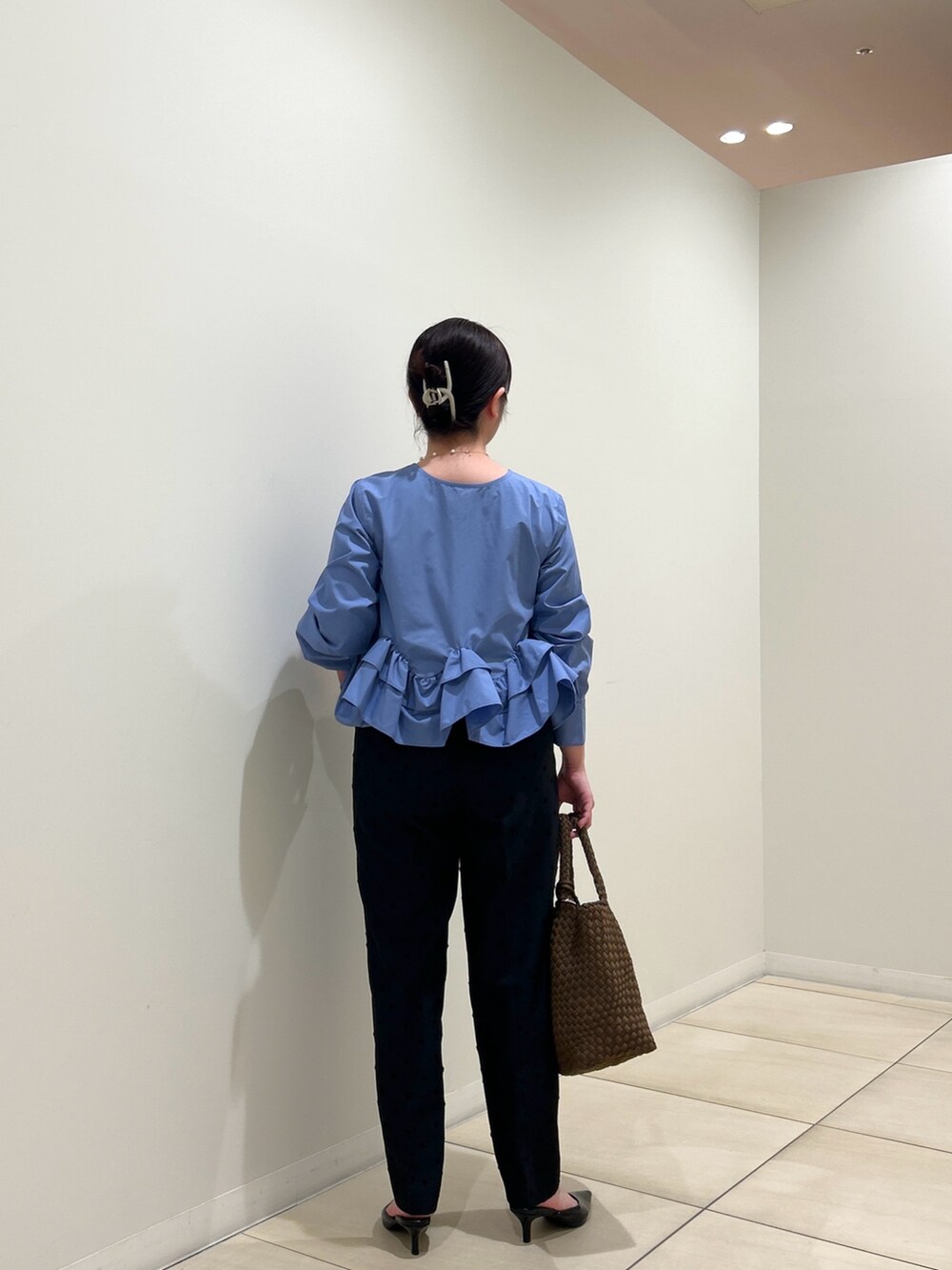 ブルー系のシャツ/ブラウス、ブラック系のその他パンツ、ブラウン系のトートバッグを着用したレディースの秋コーディネートの3枚目の写真
