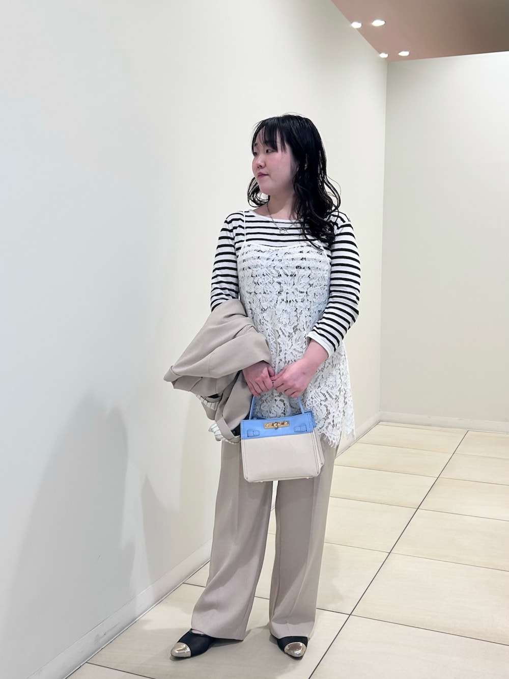 ホワイト系のキャミソール、ホワイト系のニット/セーター、ベージュ系のテーラードジャケットを着用したレディースの春コーディネートの9枚目の写真