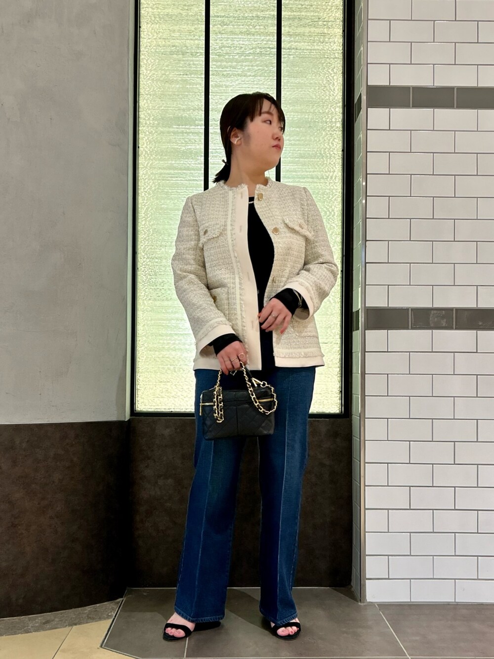 ホワイト系のノーカラージャケット、ブラック系のTシャツ/カットソー、ブルー系のデニムパンツを着用したレディースの夏コーディネートの2枚目の写真