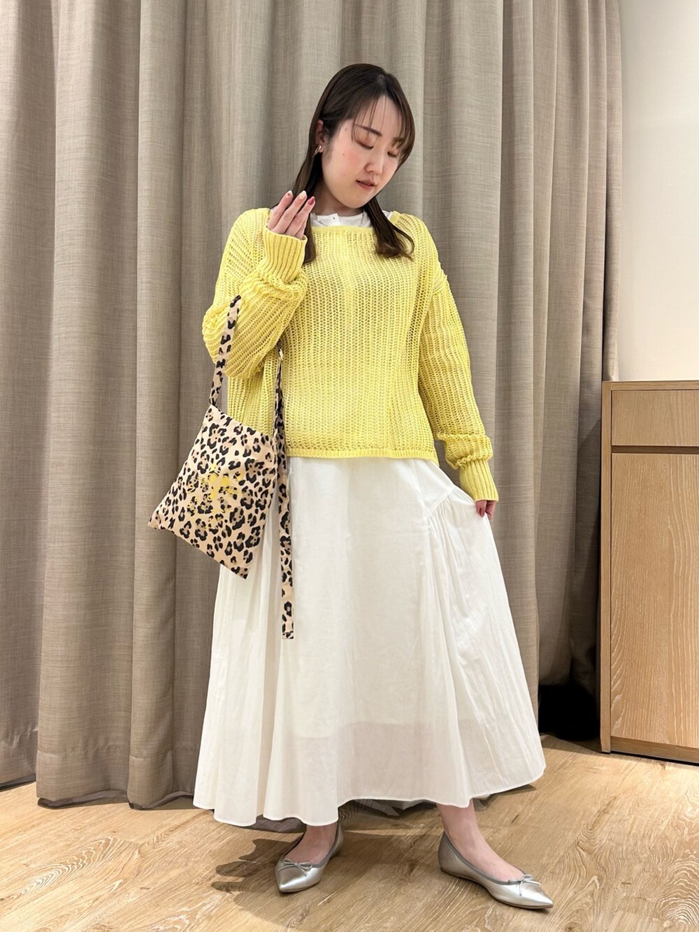 イエロー系のニット/セーター、ホワイト系のTシャツ/カットソー、ホワイト系のスカートを着用したレディースの春コーディネートの7枚目の写真