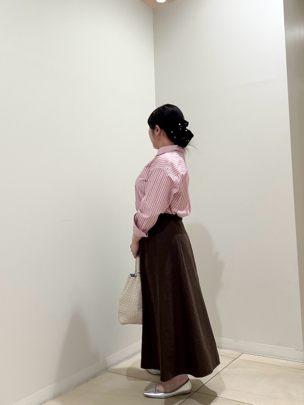 ピンク系のシャツ/ブラウス、ブラウン系のスカート、ホワイト系のショルダーバッグを着用したレディースの秋コーディネートの2枚目の写真