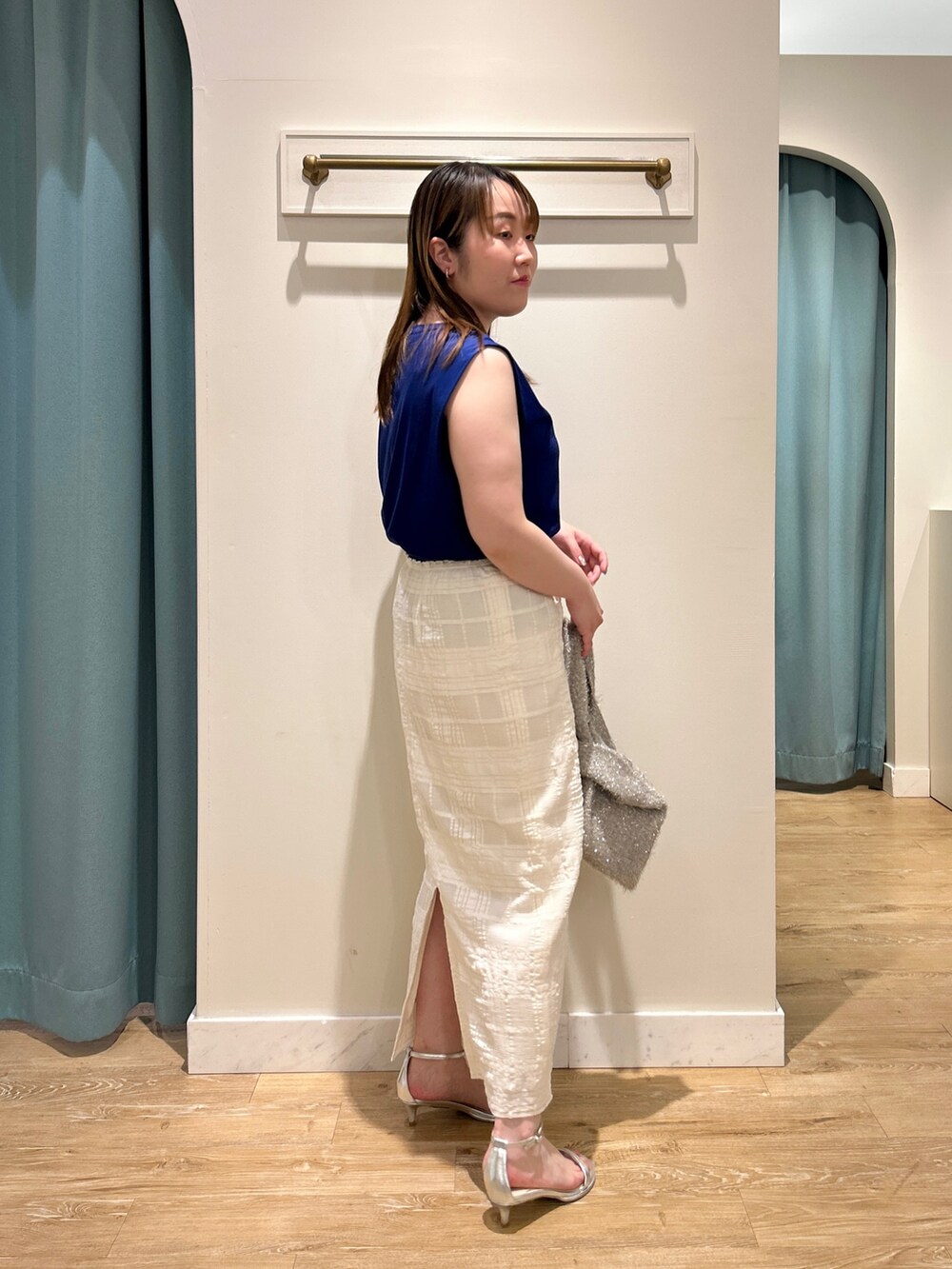 ブルー系のTシャツ/カットソー、ホワイト系のスカート、ベージュ系のバックパック/リュックを着用したレディースの夏コーディネートの5枚目の写真