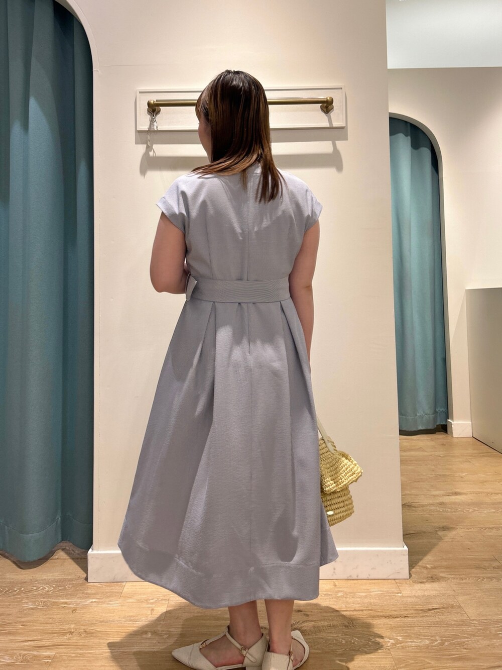 ブルー系のワンピース、ベージュ系のかごバッグ、シルバー系のネックレスを着用したレディースの夏コーディネートの5枚目の写真