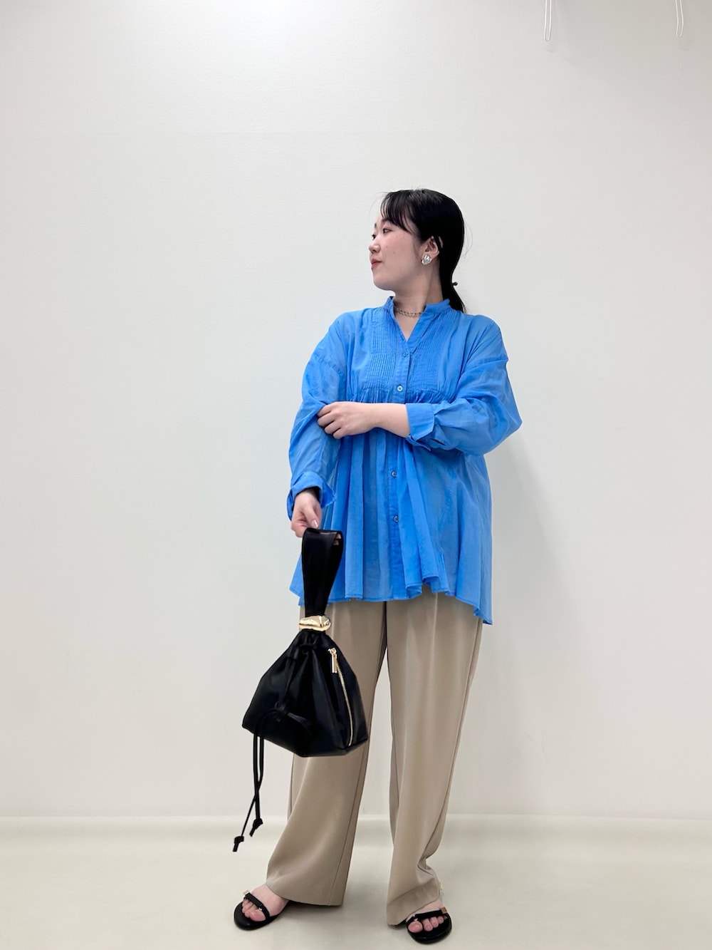 ブルー系のシャツ/ブラウス、ベージュ系のその他パンツ、ブラック系のショルダーバッグを着用したレディースの秋コーディネートの4枚目の写真