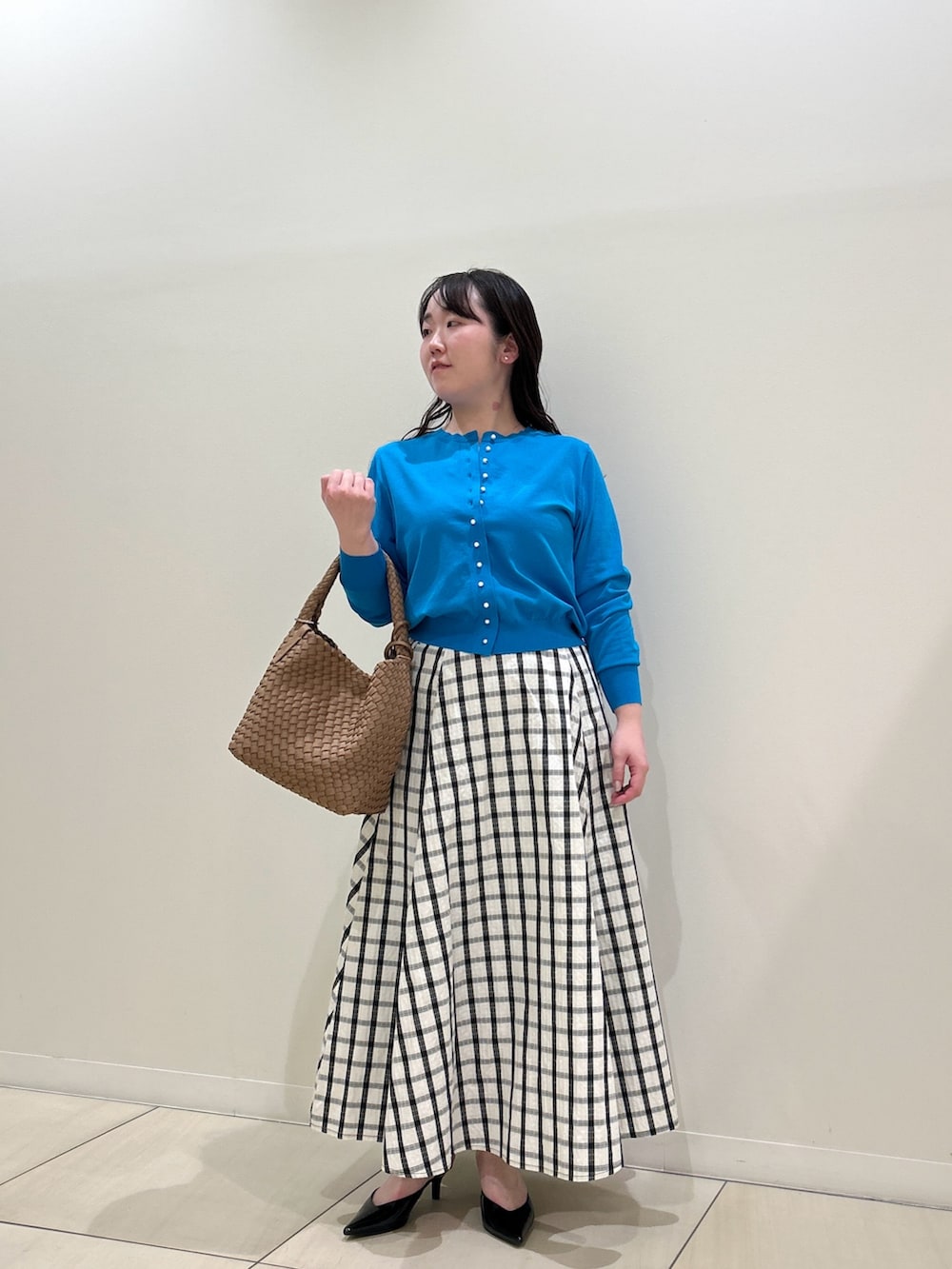 ブルー系のカーディガン/ボレロ、ホワイト系のスカート、ブラウン系のショルダーバッグを着用したレディースの春コーディネートの6枚目の写真