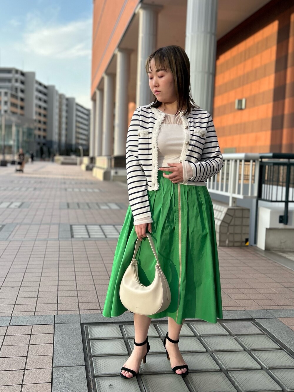 ホワイト系のカーディガン/ボレロ、グリーン系のスカート、ホワイト系のTシャツ/カットソーを着用したレディースの冬コーディネートの8枚目の写真