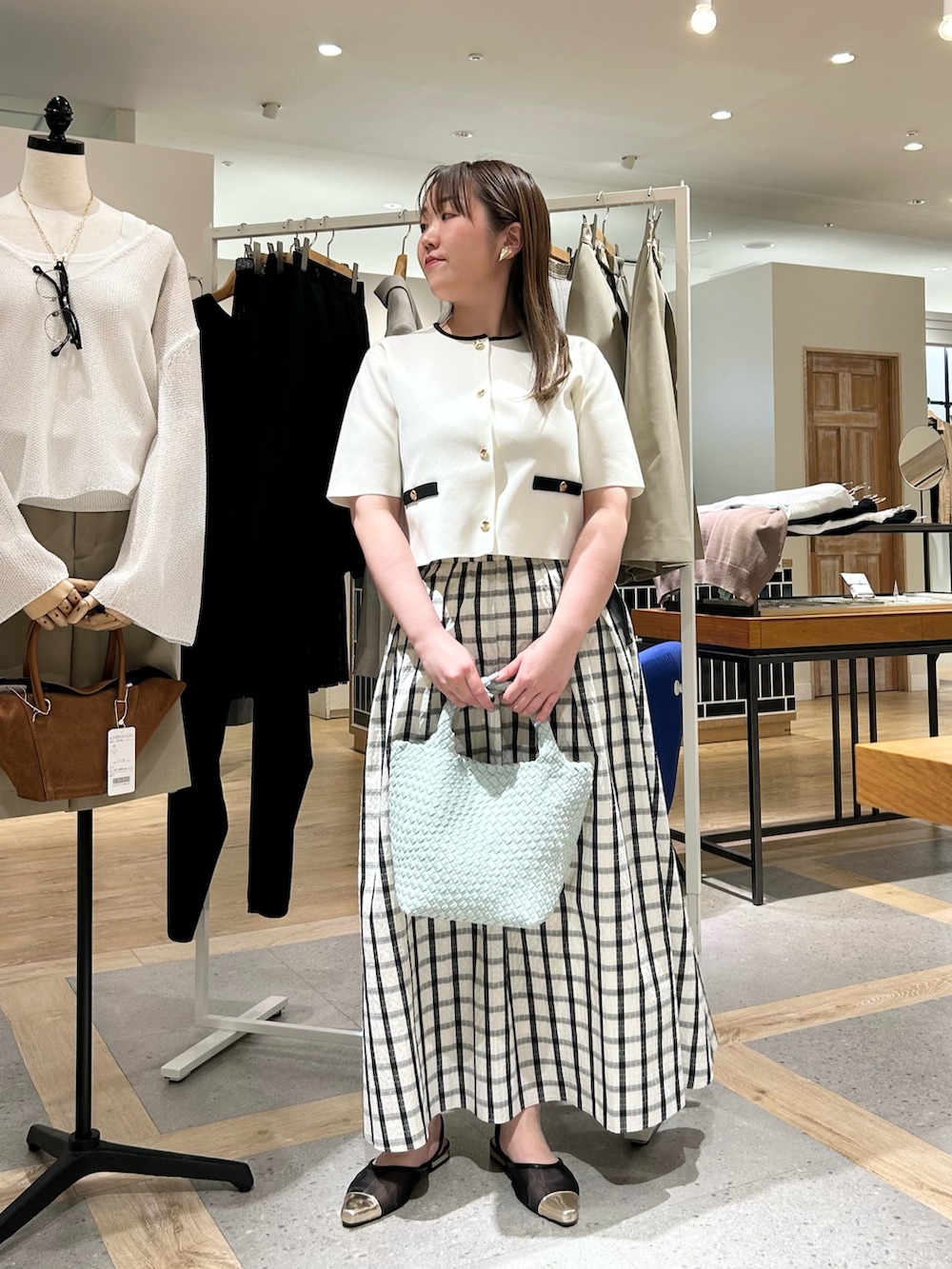 ホワイト系のノーカラージャケット、グリーン系のショルダーバッグ、ゴールド系のイヤリングを着用したレディースの夏コーディネートの8枚目の写真