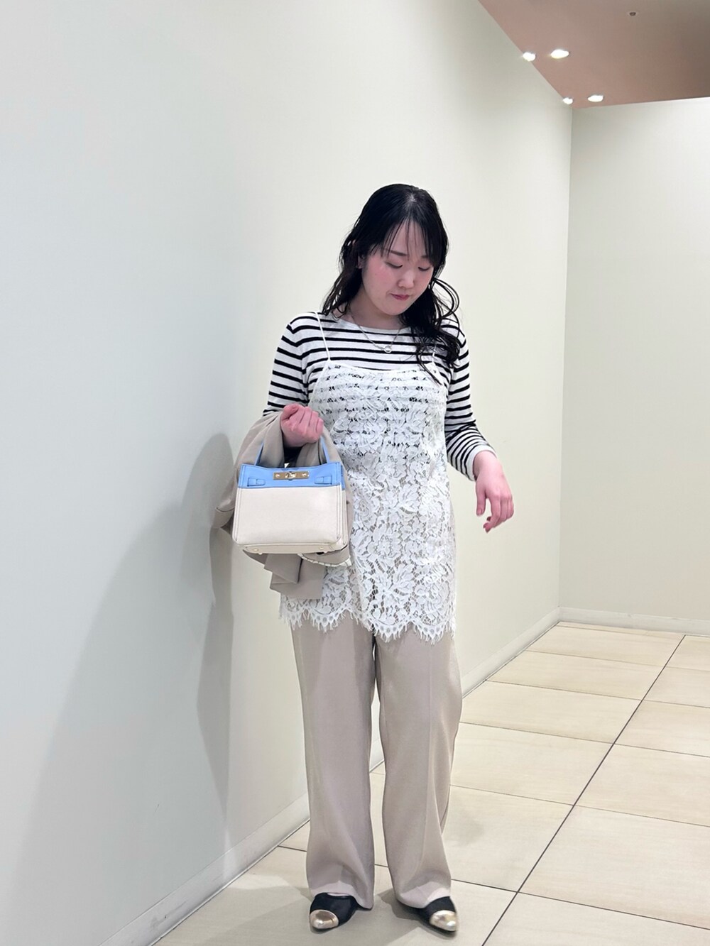 ホワイト系のキャミソール、ホワイト系のニット/セーター、ベージュ系のテーラードジャケットを着用したレディースの春コーディネートの6枚目の写真