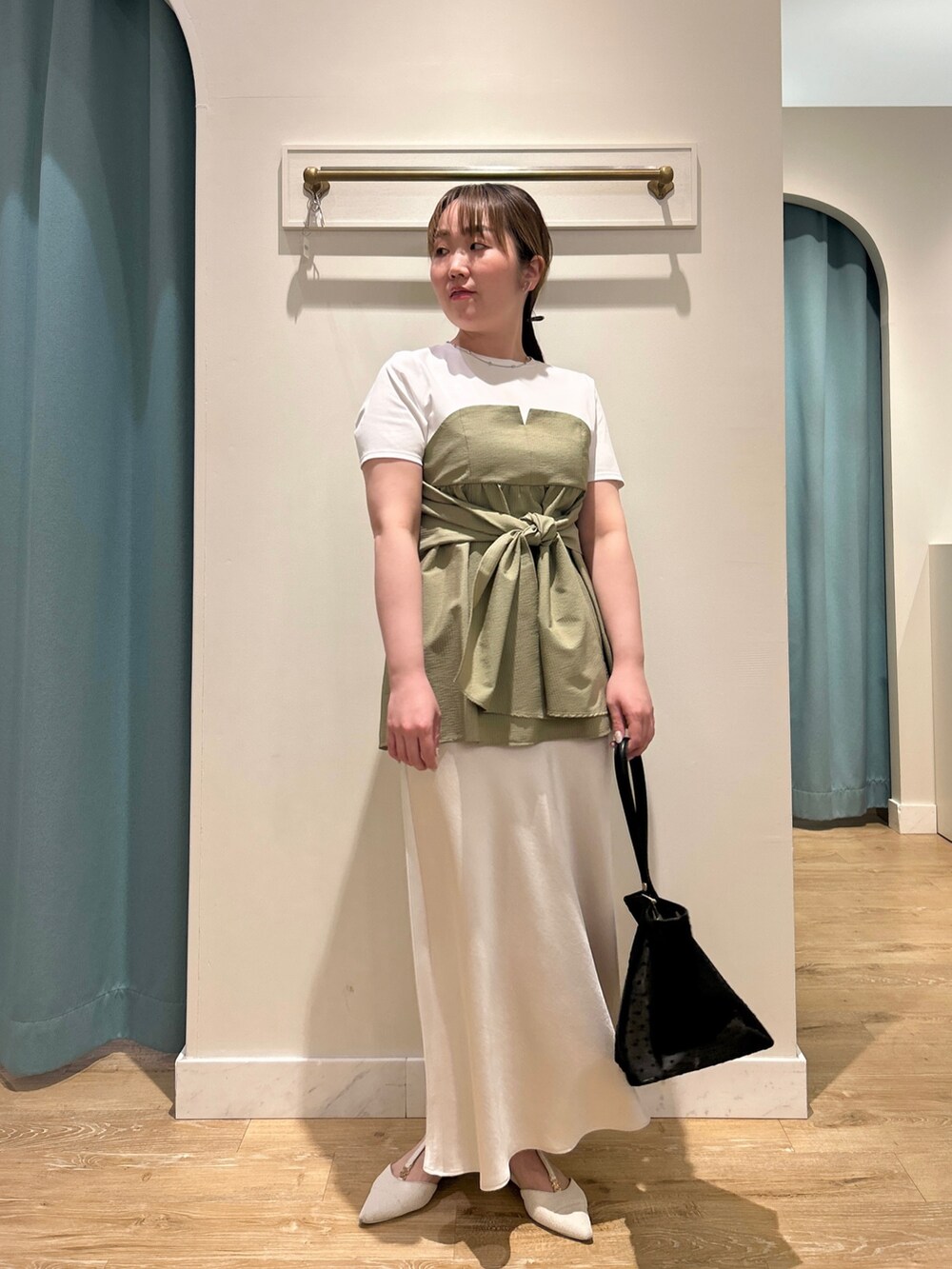 グリーン系のTシャツ/カットソー、ホワイト系のスカート、ブラック系のトートバッグを着用したレディースの夏コーディネートの7枚目の写真