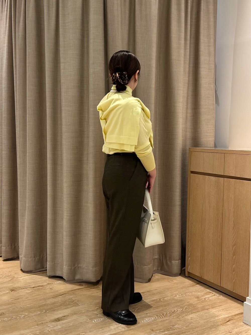 イエロー系のニット/セーター、イエロー系のカーディガン/ボレロ、ブラウン系のその他パンツを着用したレディースの秋コーディネートの4枚目の写真