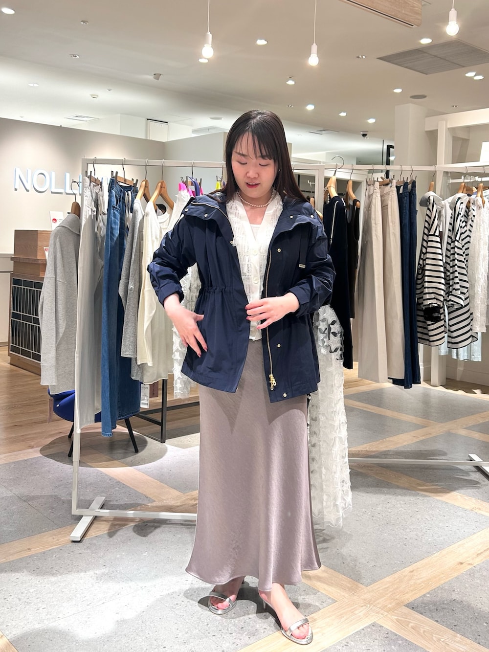 ホワイト系のカーディガン/ボレロ、グリーン系のスカート、ブルー系のブルゾンを着用したレディースの春コーディネートの7枚目の写真