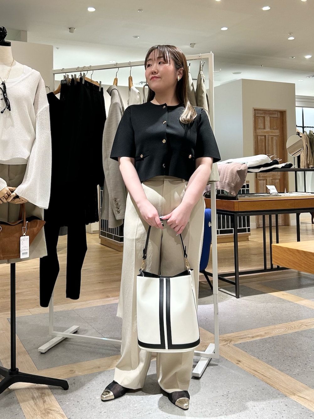 ブラック系のノーカラージャケット、ベージュ系のその他パンツ、ホワイト系のショルダーバッグを着用したレディースの夏コーディネートの10枚目の写真