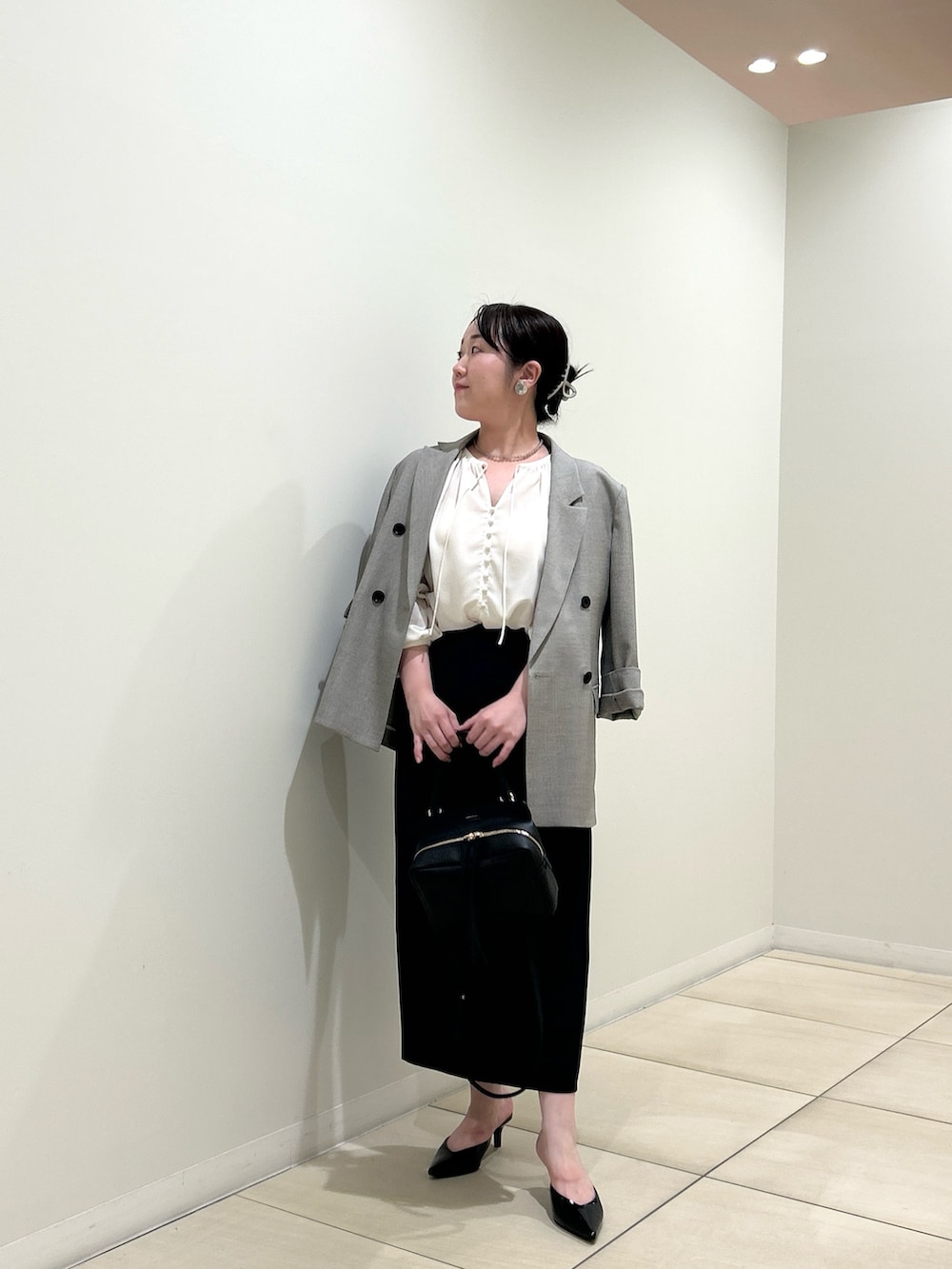 ベージュ系のテーラードジャケット、ホワイト系のシャツ/ブラウス、ブラック系のスカートを着用したレディースの秋コーディネートの5枚目の写真